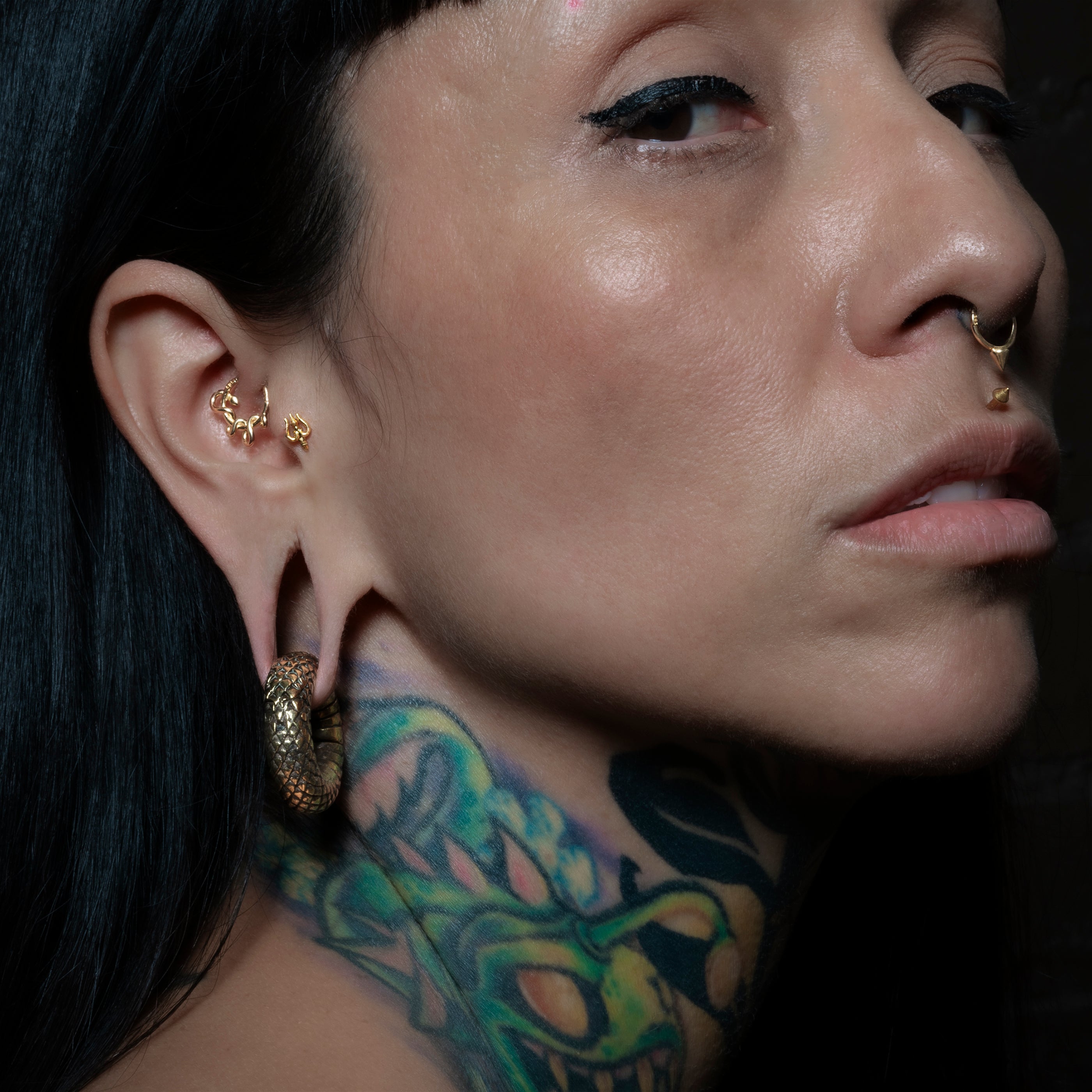 model wearing 18K Gold Trishula Flat Back Stud on her tragus
