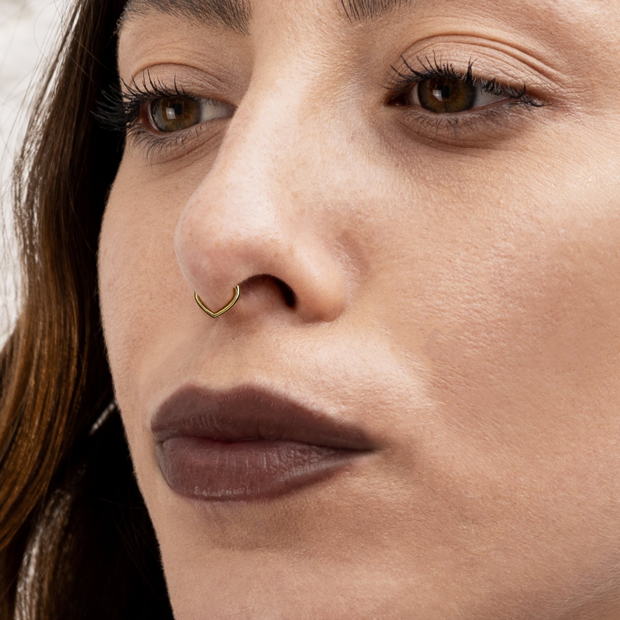 model wearing 14k gold teardrop clicker ring on hew septum