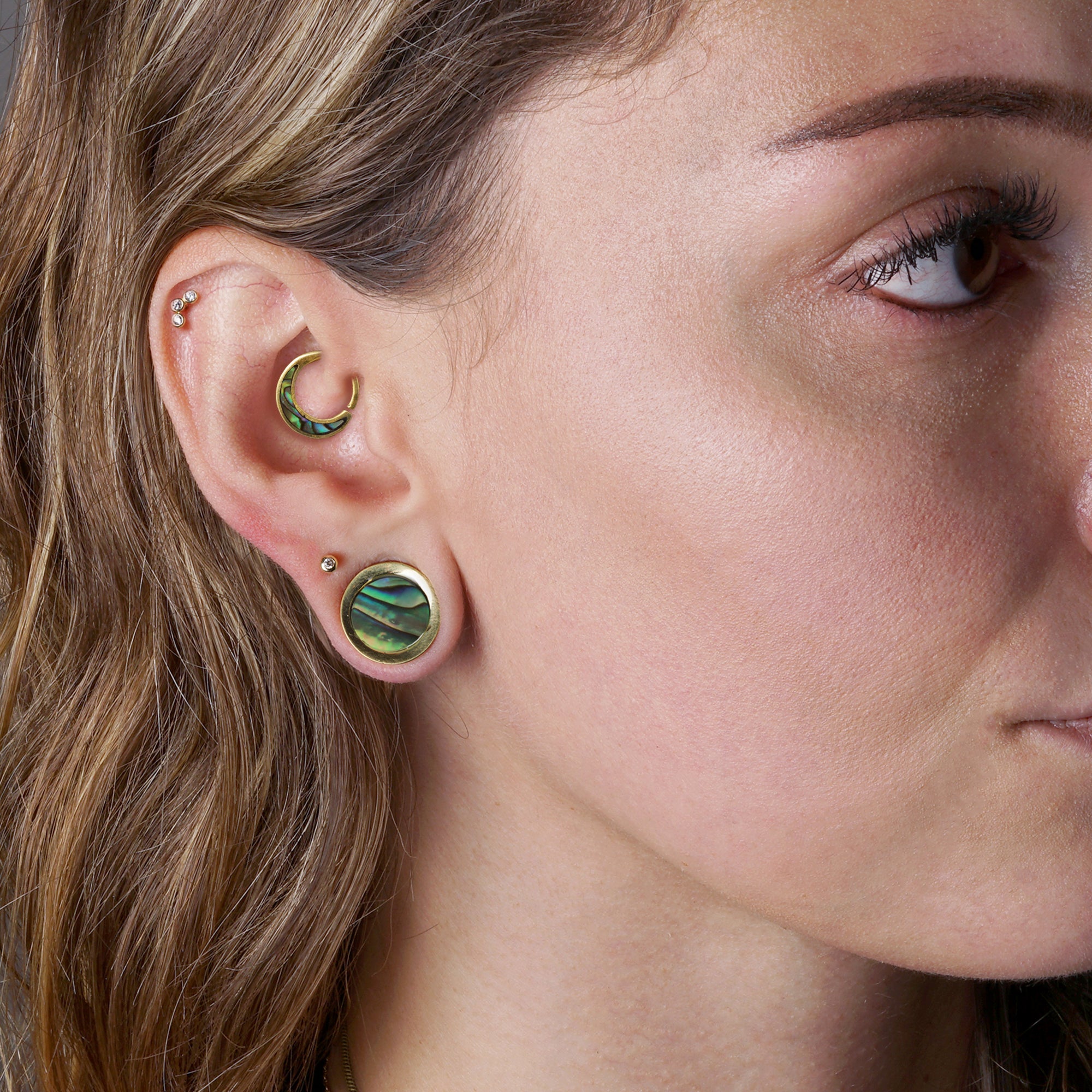 model wearing Golden Plugs with Abalone and Aanya Abalone piercing ring on her daith