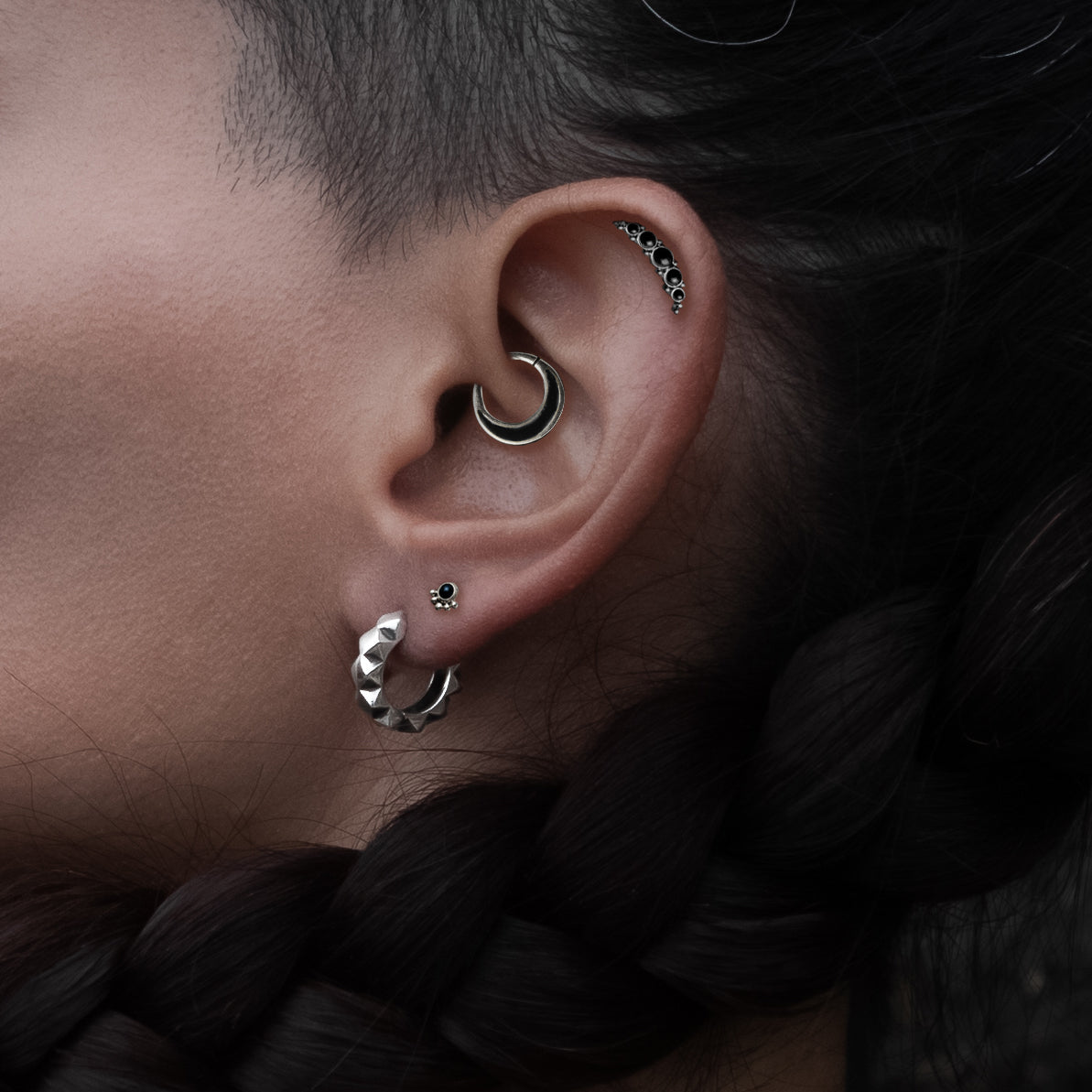 model wearing Layla Labret with Onyx on her upper lobe Aanya Black Shell Silver Septum piercing ring on her daith and Quintuple Onyx Deva Labret on her helix