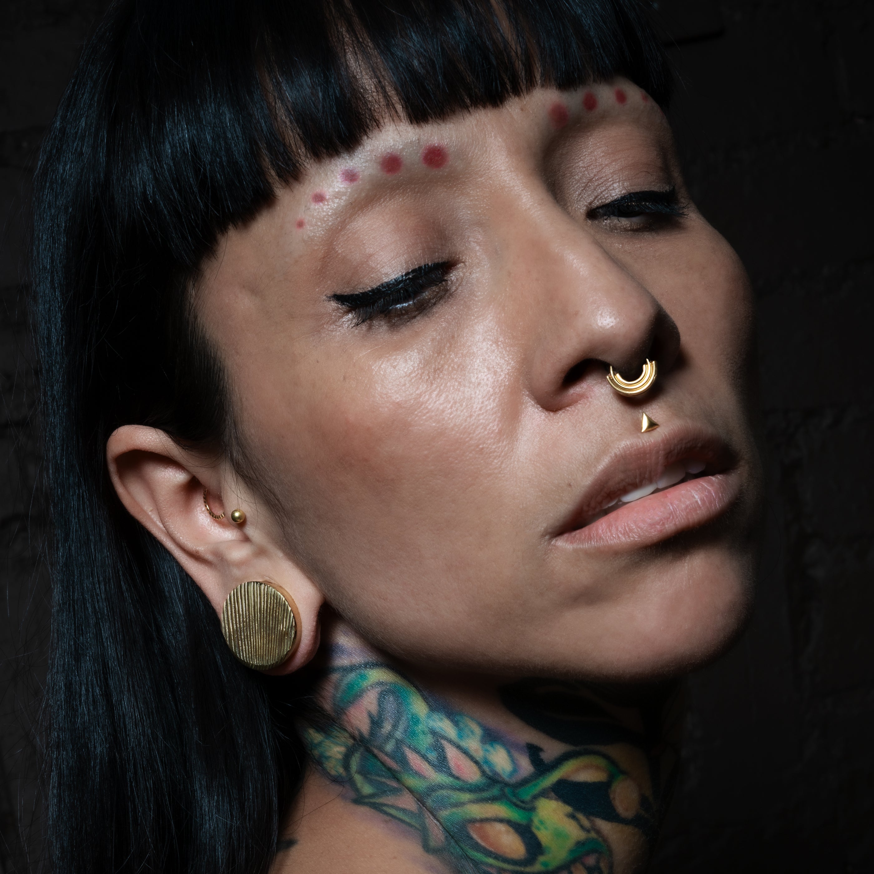 model wearing 18K Gold Dot Flat Back Stud on her tragus
