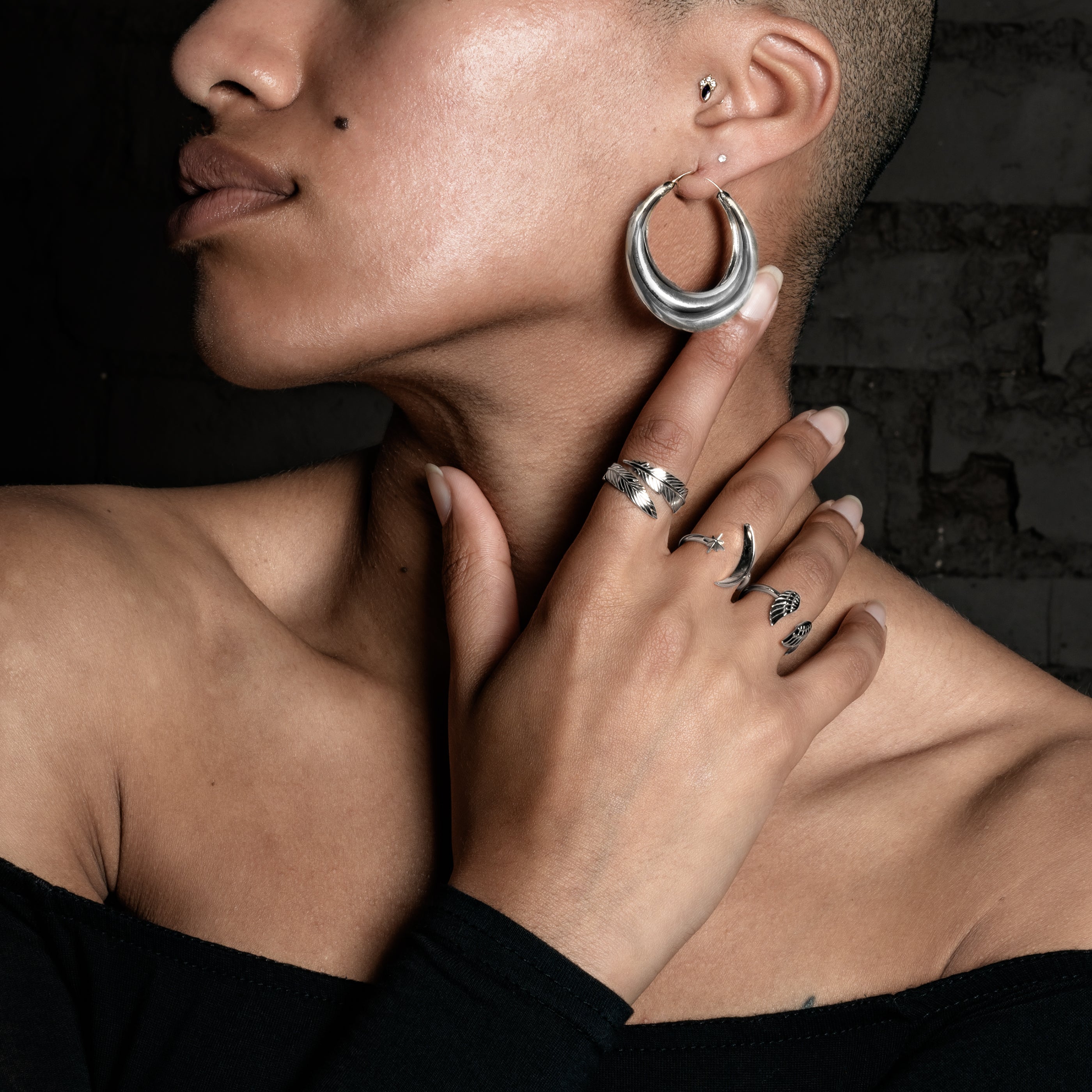 model wearing Open Feather Bronze Ring, Celestial ring, Wings ring and snake ring