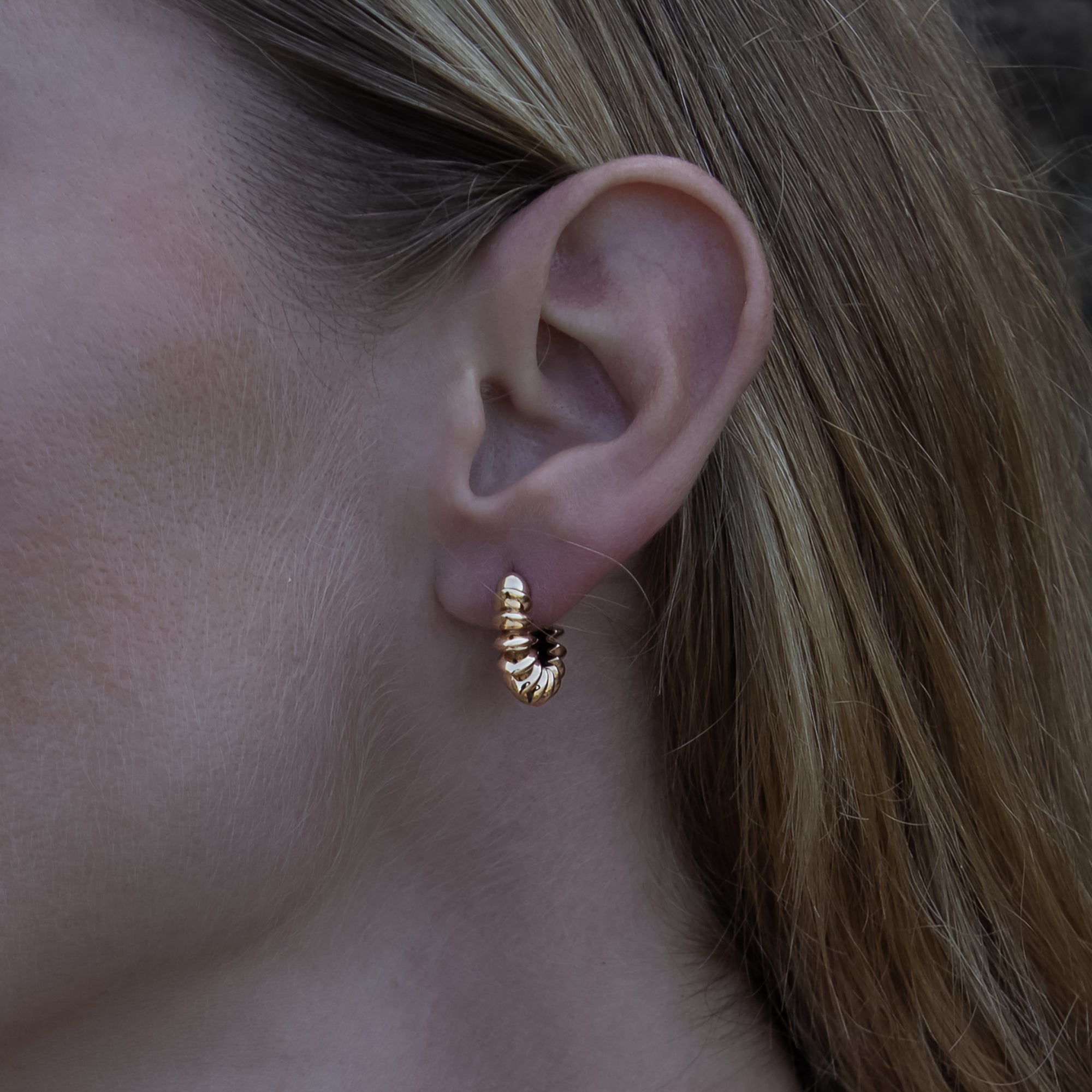 model wearing golden bronze Surya Huggies Hoop earrings