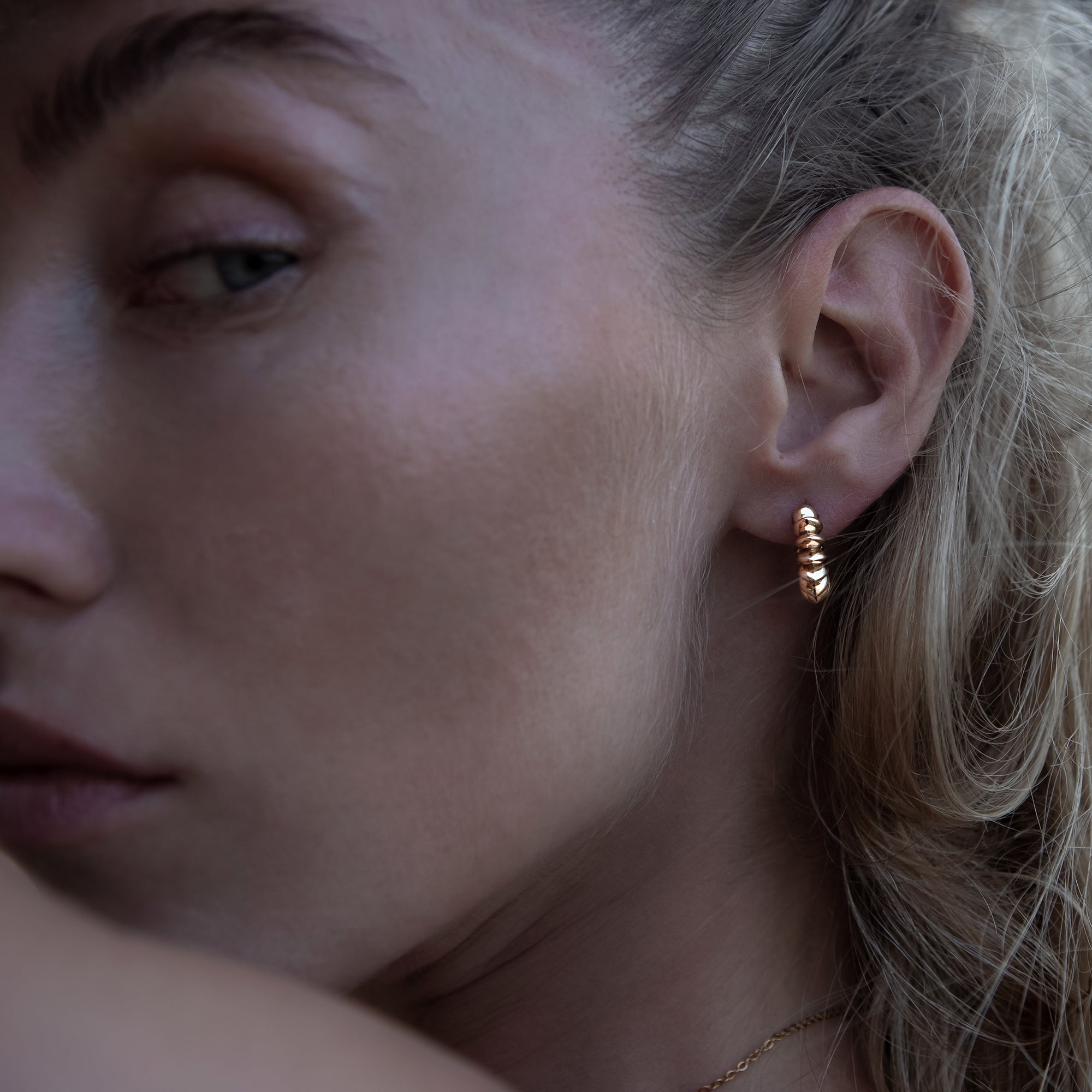 model wearing golden bronze Surya Huggies Hoop earrings