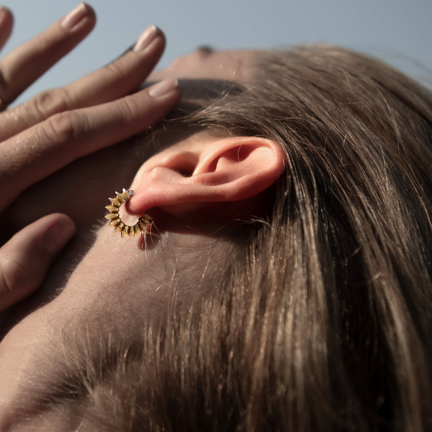 model wearing golden bronze Surya Huggies Hoop earrings