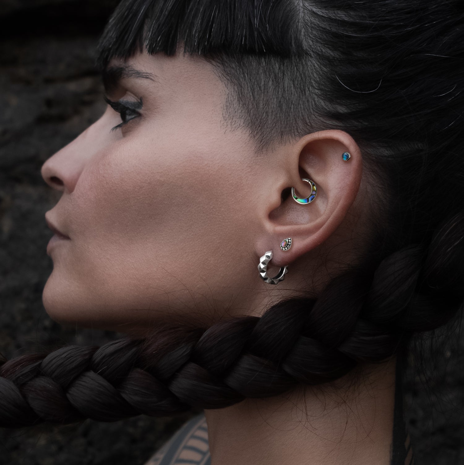 model wearing Aanya Abalone Silver Septum piercing ring on her daith, Tara Labret with Abalone on her upper lobe and Labret with Abalone on her helix