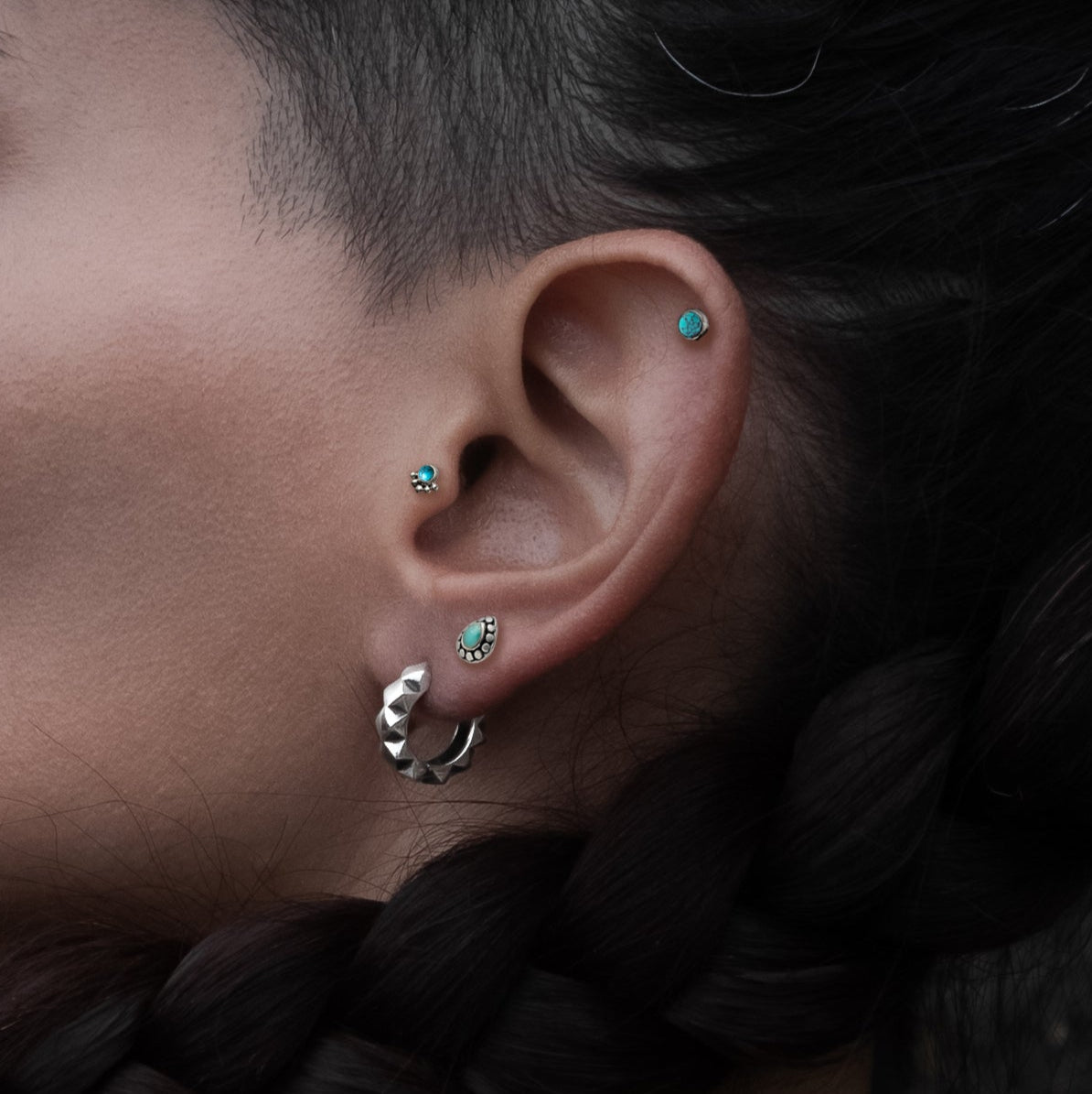 model wearing Layla Labret with Turquoise on her tragus, Tarat labret on her upper lobe and titanium labret on her helix