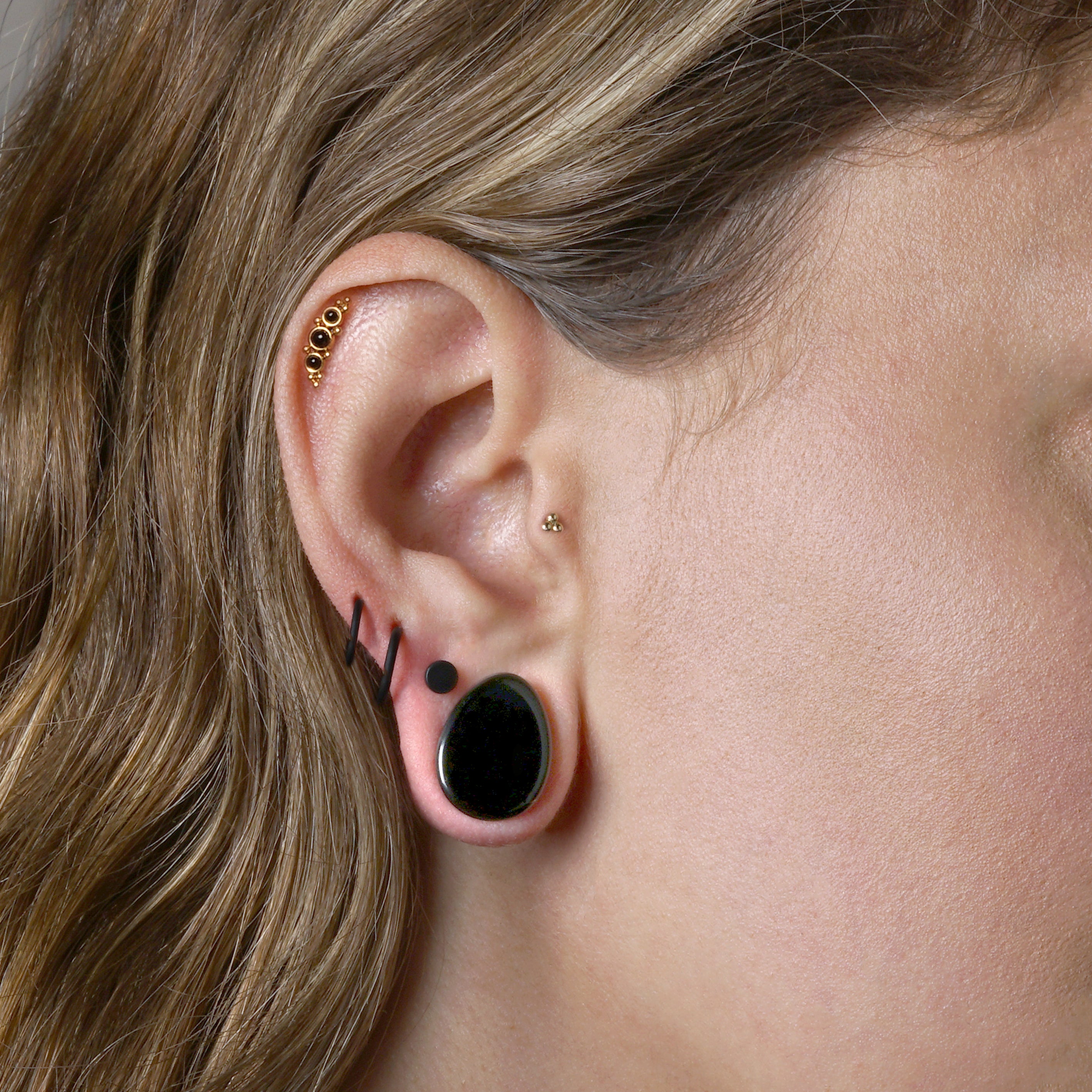 model wearing Deva Golden Labret with Onyx on her helix