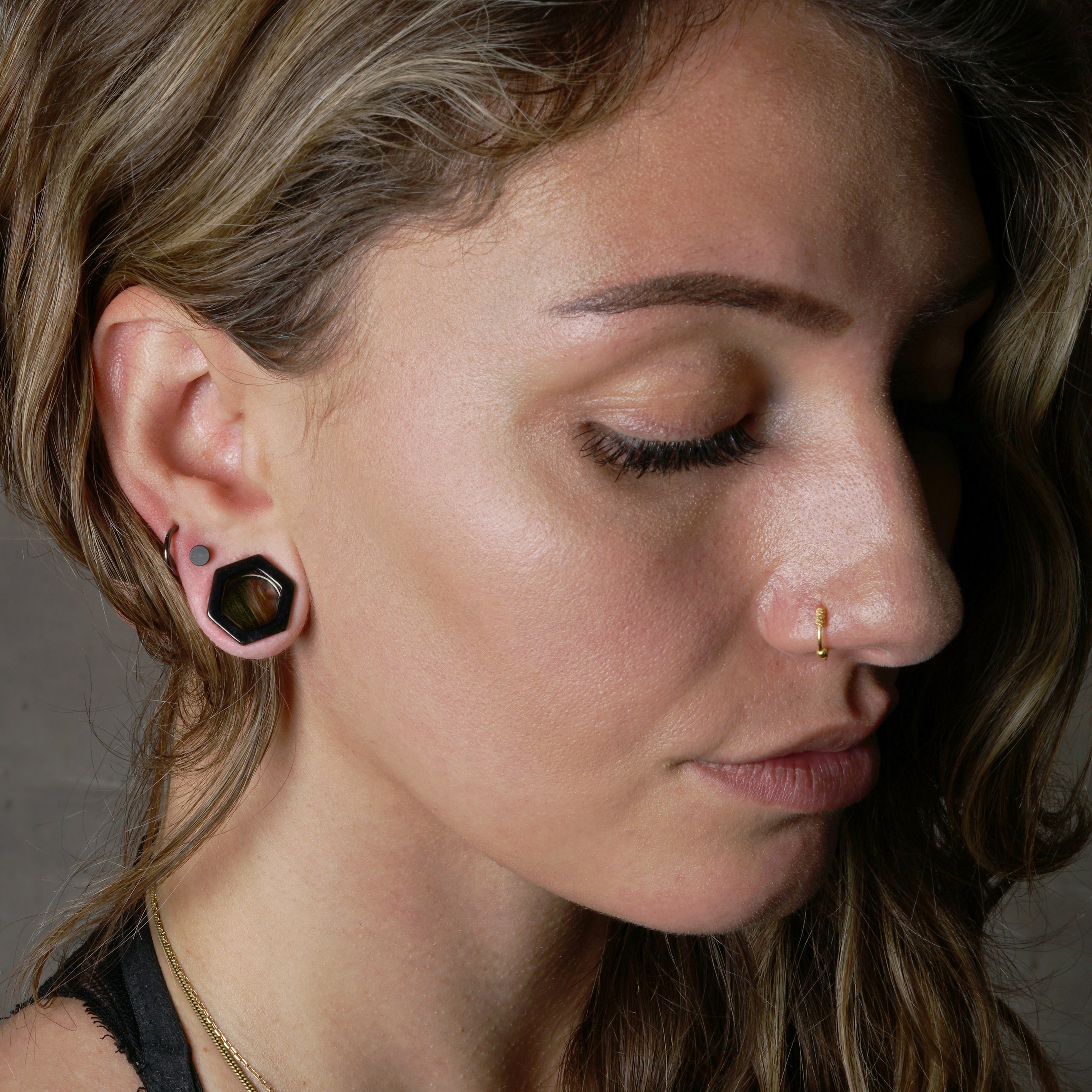 model wearing surgical steel black hexagon ear tunnel