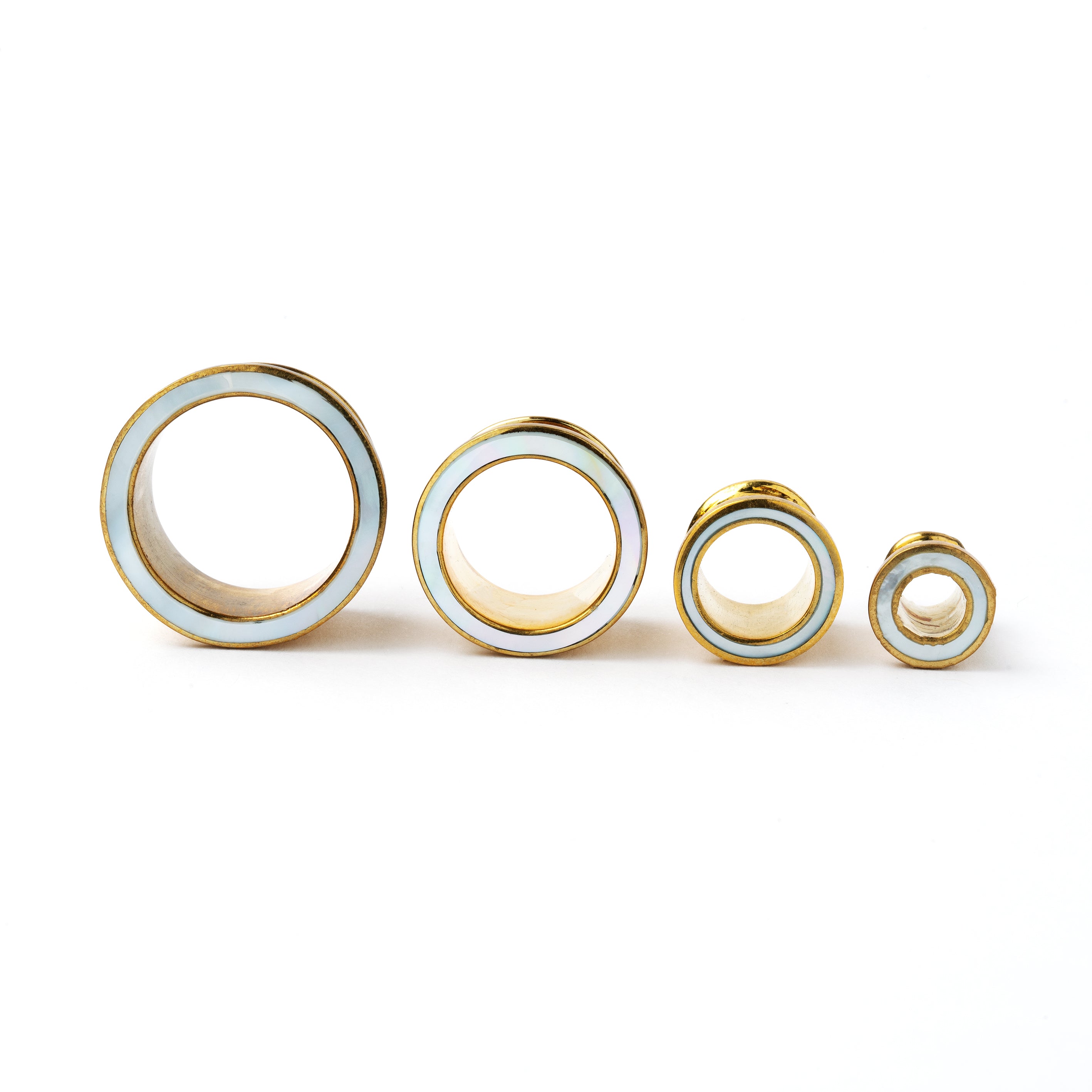 several sizes of golden brass with MOP ear tunnels front view