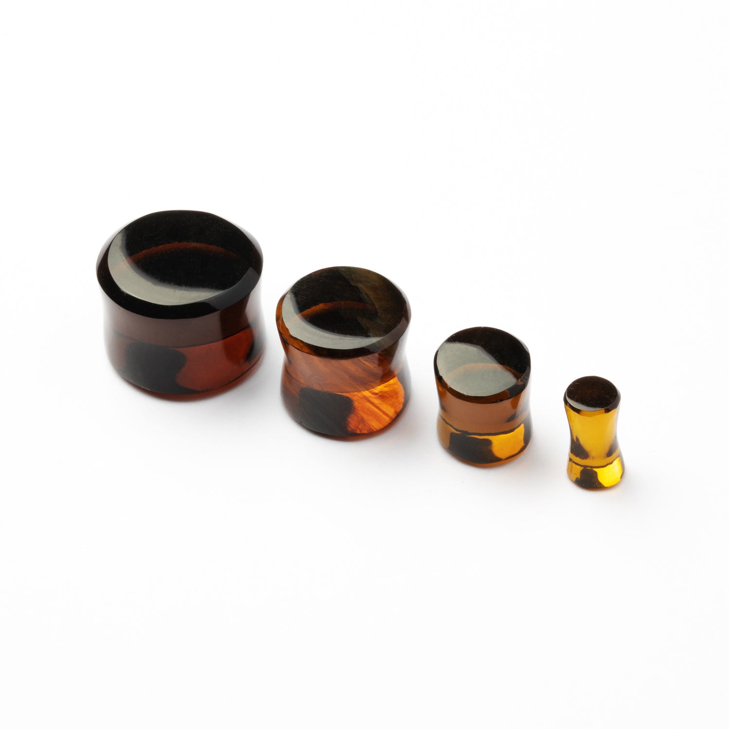 several sizes of Brown Volcanic Glass double flare ear plugs side front view