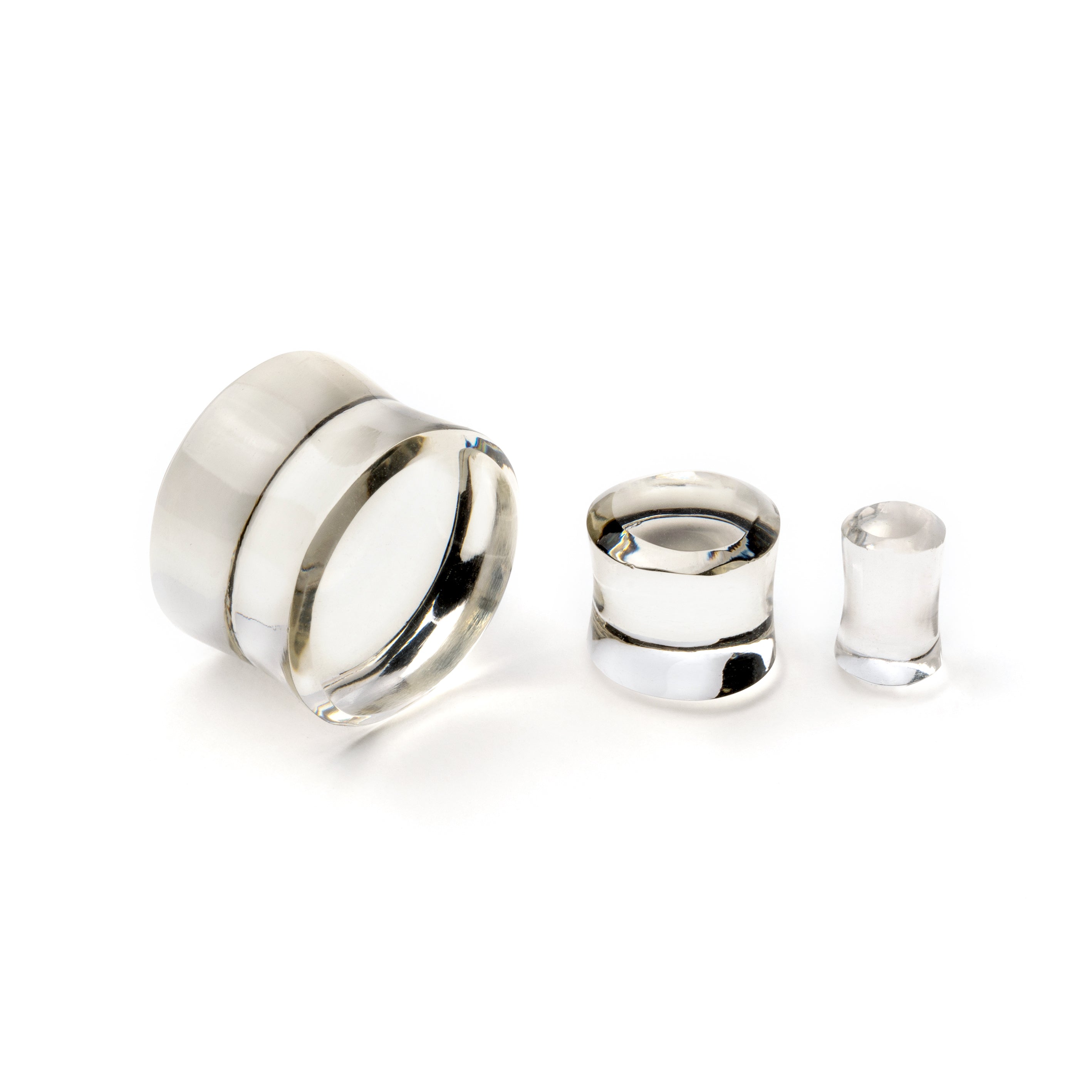 several sizes of Clear Volcanic Glass double flare ear plugs different angles