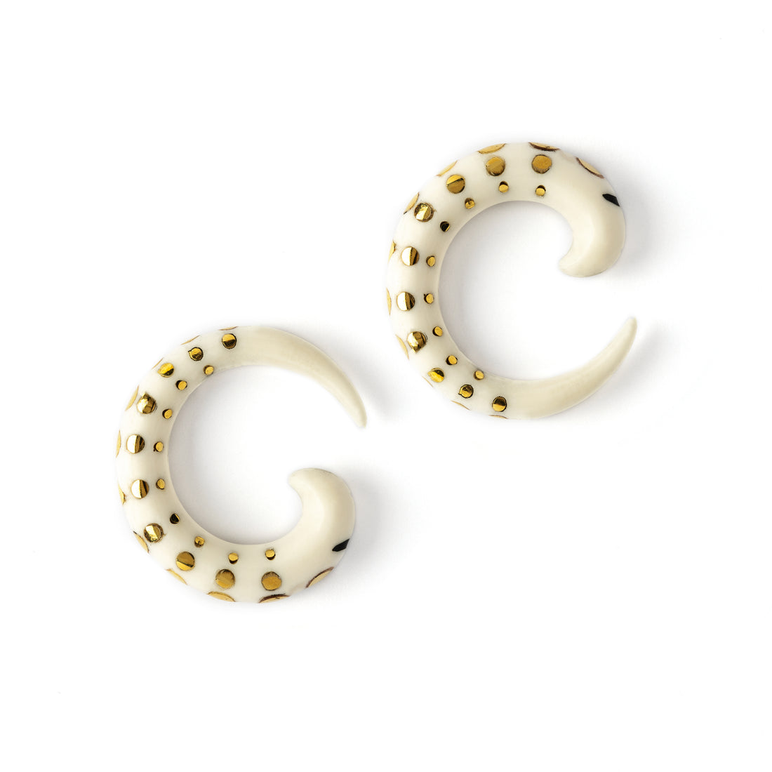 pair of white bone taper ear stretchers with golden dots side view