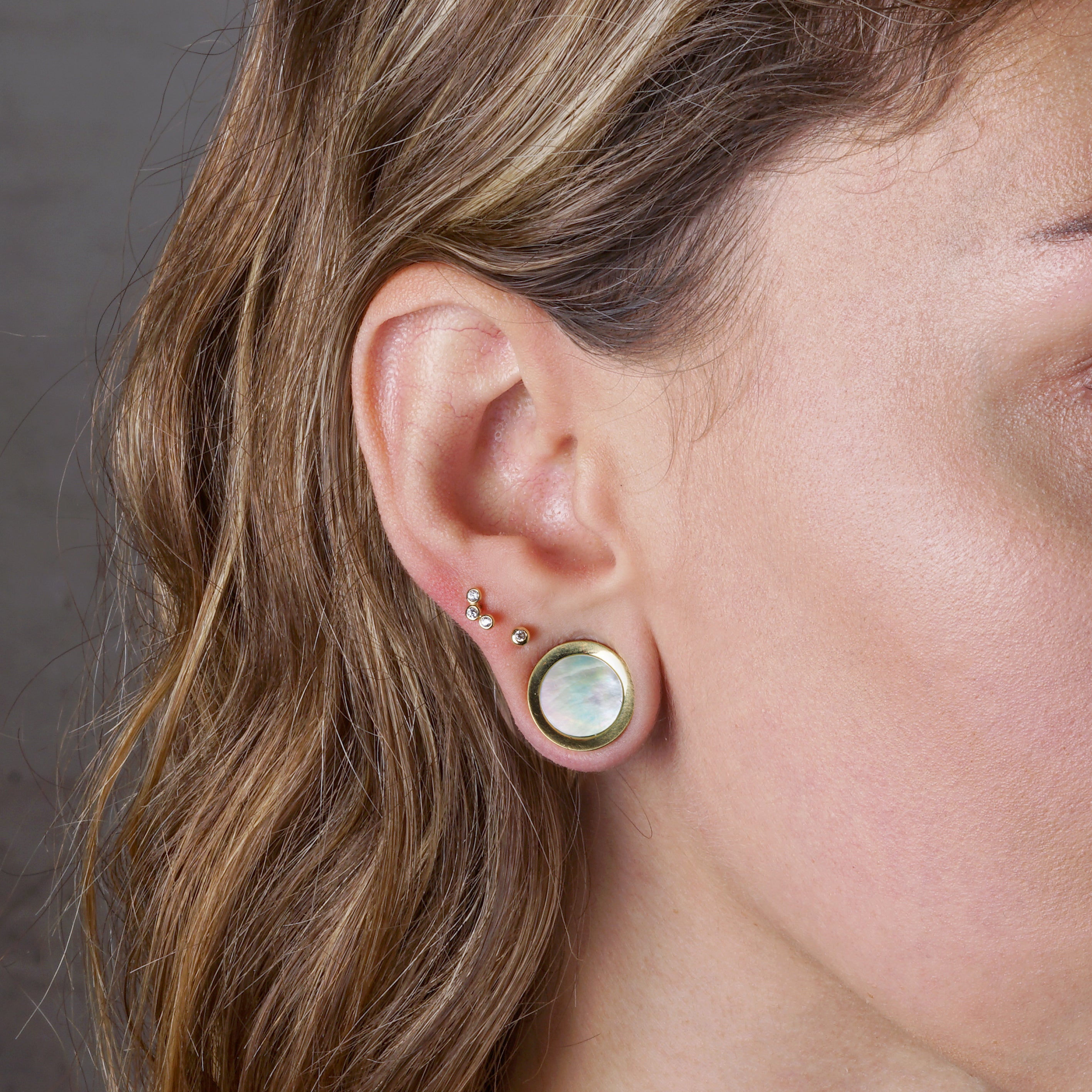 model wearing Golden Plugs with a Mother of Pearl