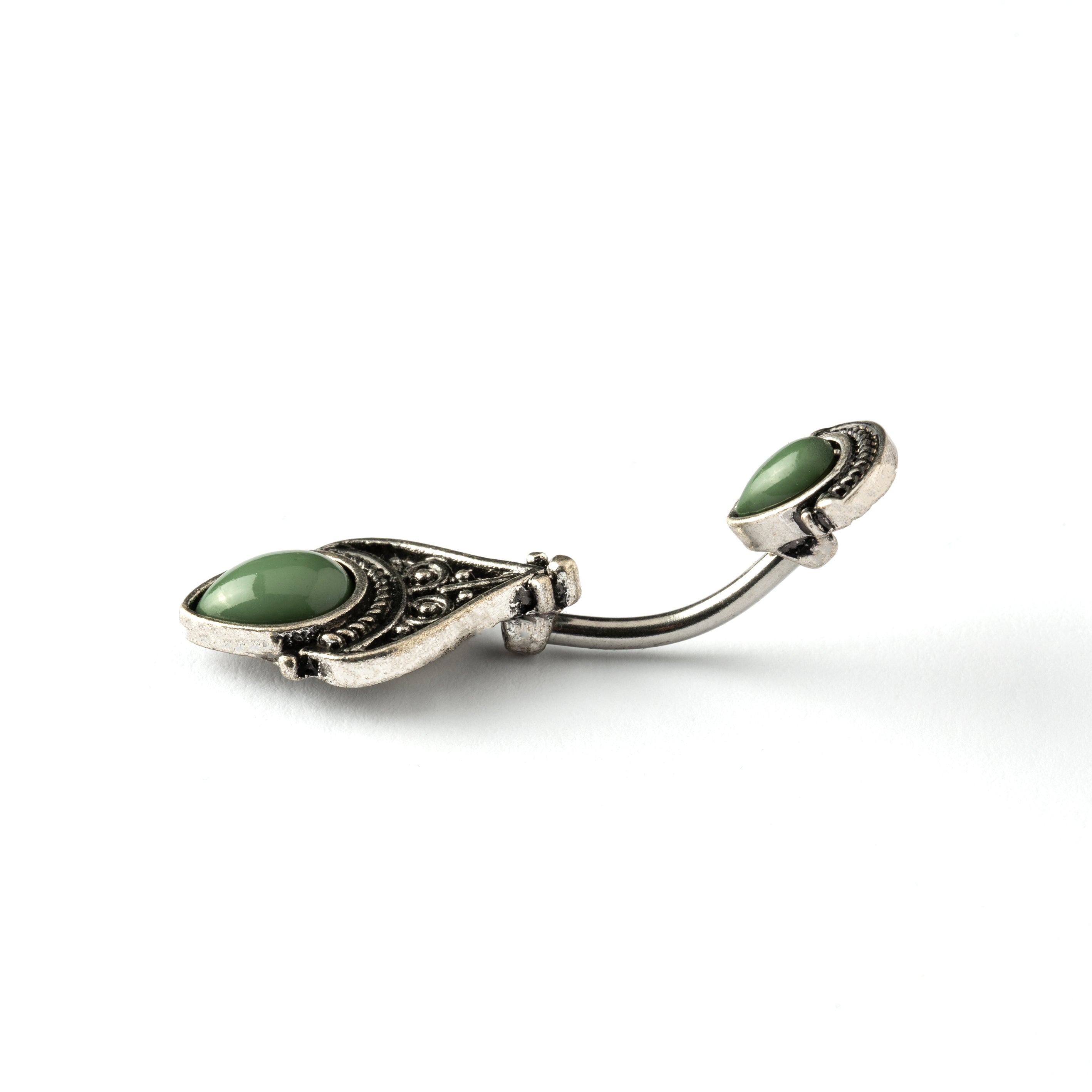 navel bar with silver toned goth ornament with two green stones one at the top and one at the bottom side view