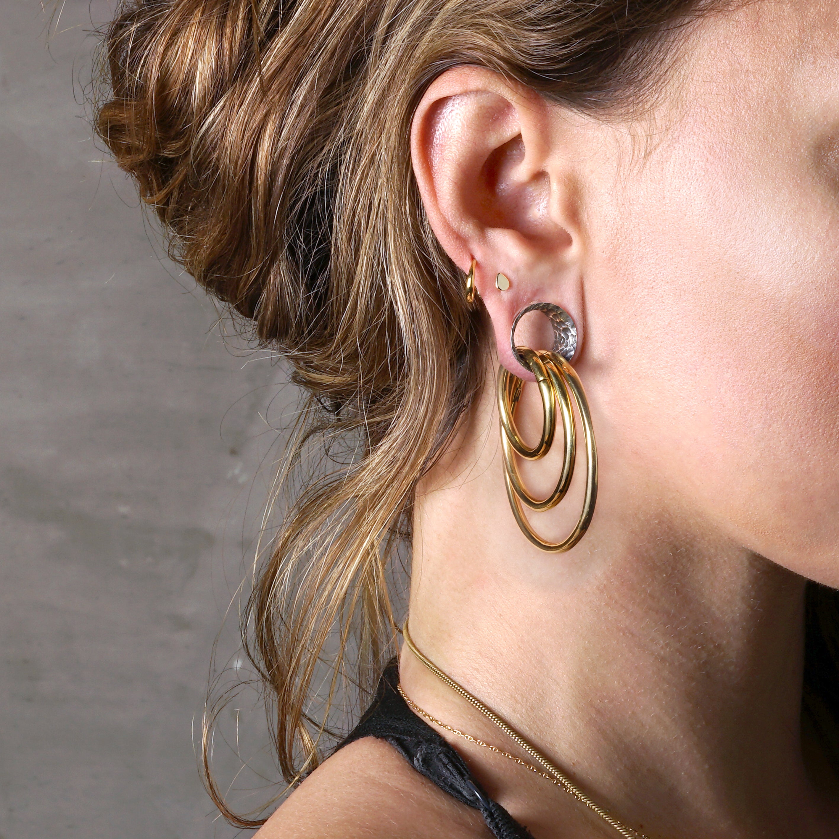 model wearing stacking hoop hangers with hammered silver tunnel