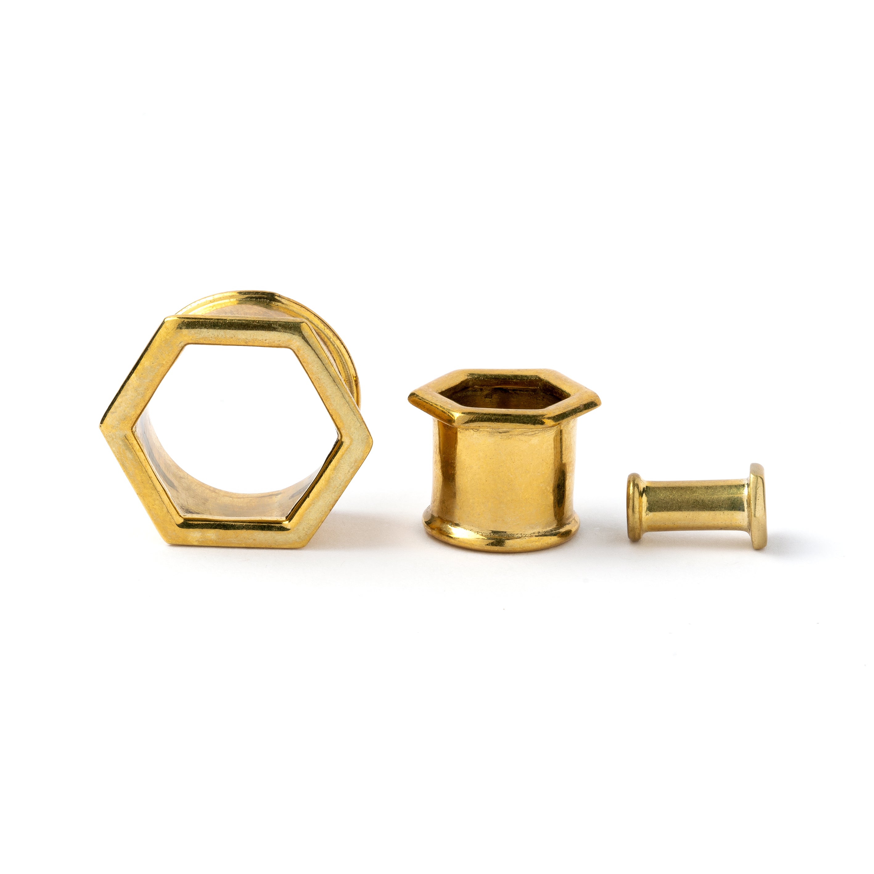 several sizes of golden brass hexagon ear tunnels front and side view