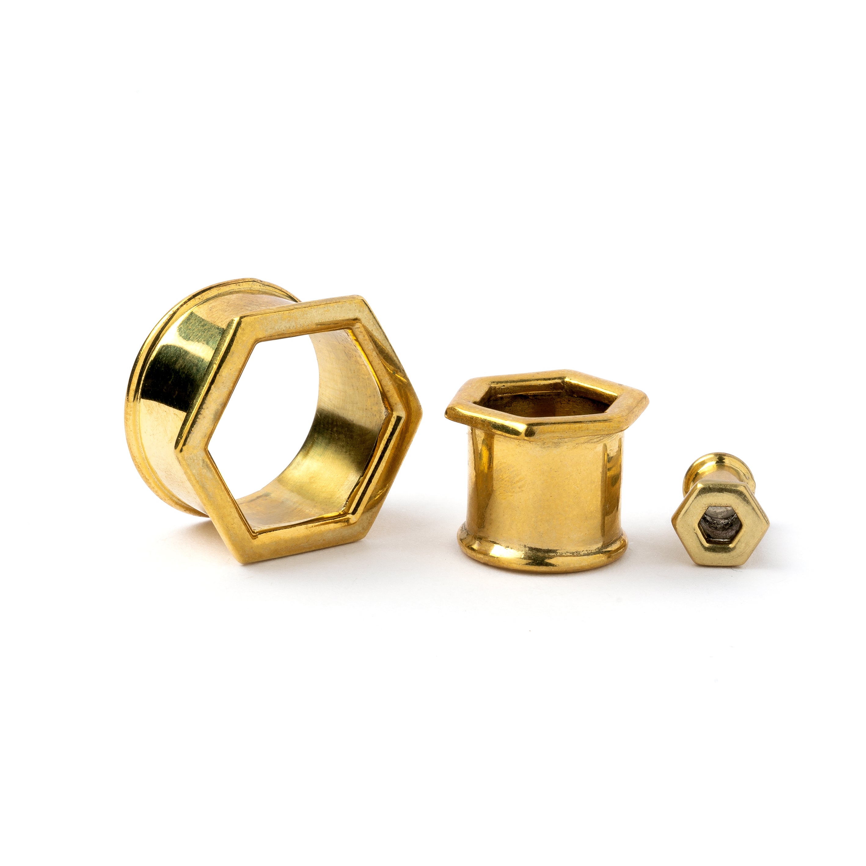 several sizes of golden brass hexagon ear tunnels front and side