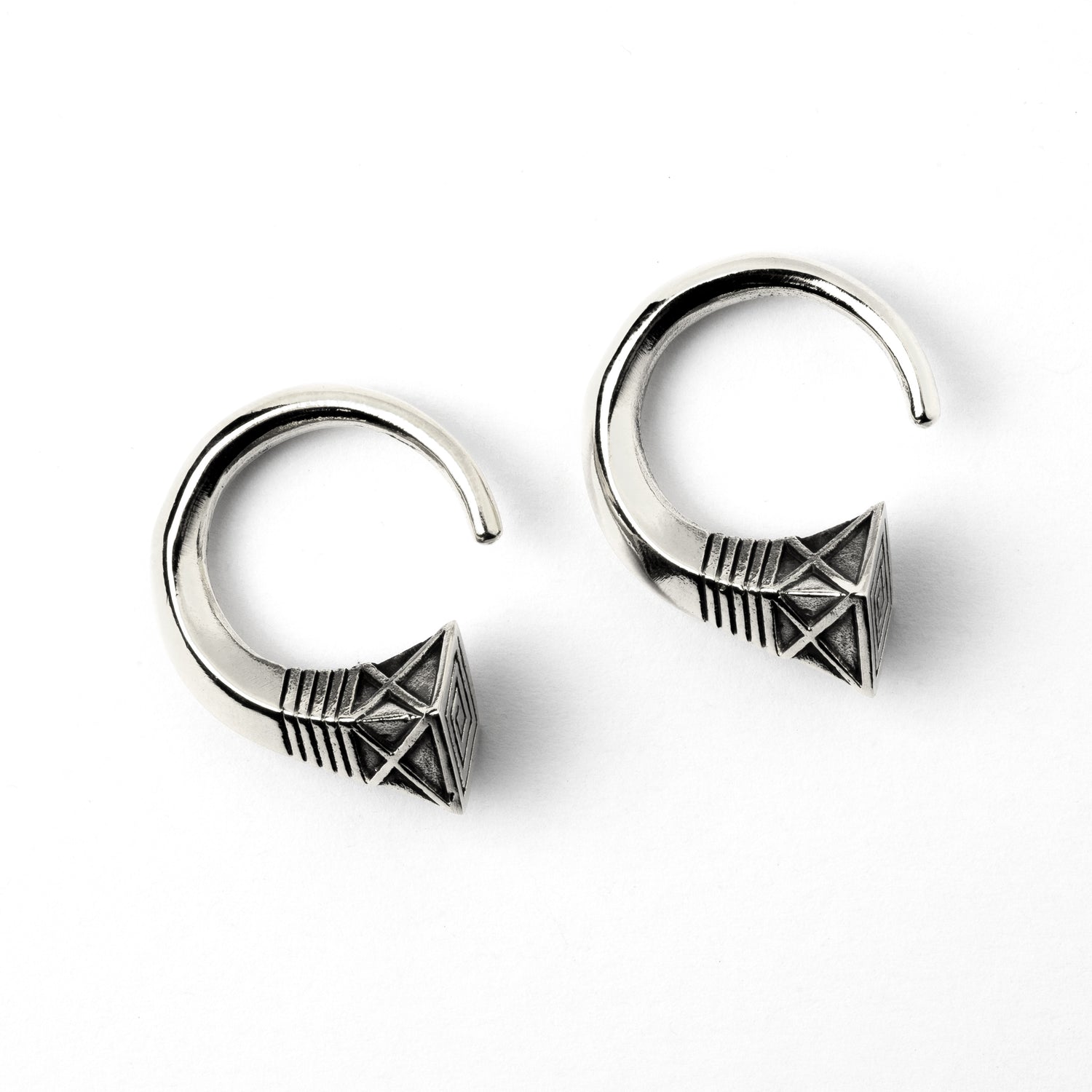 pair of white brass hook weights hangers with geometric design frontal view