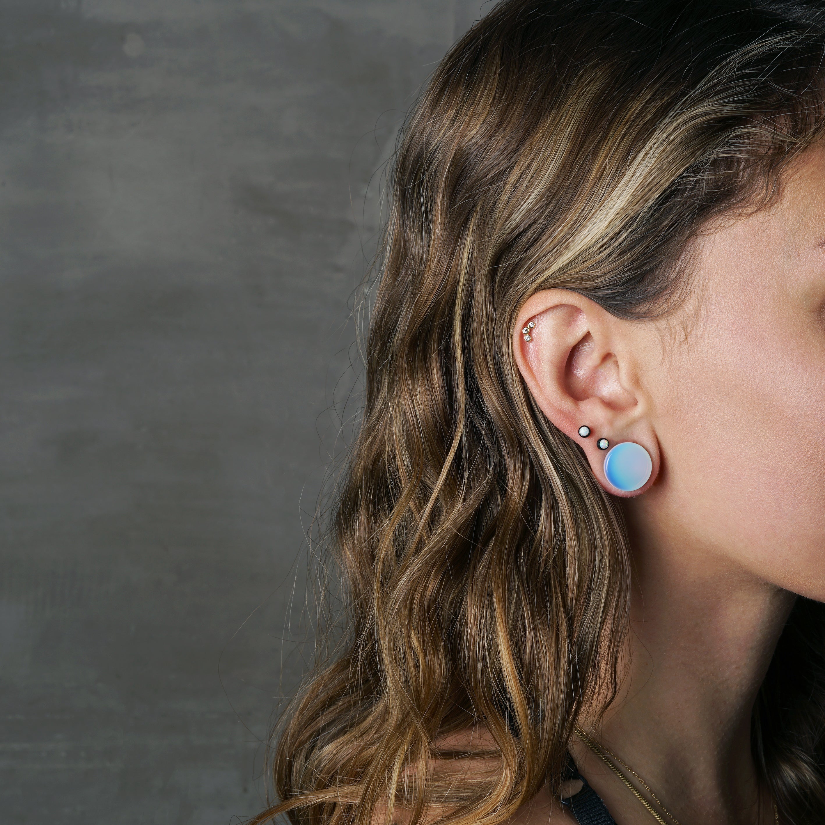 model wearing Opalite stone plug with double flared ends
