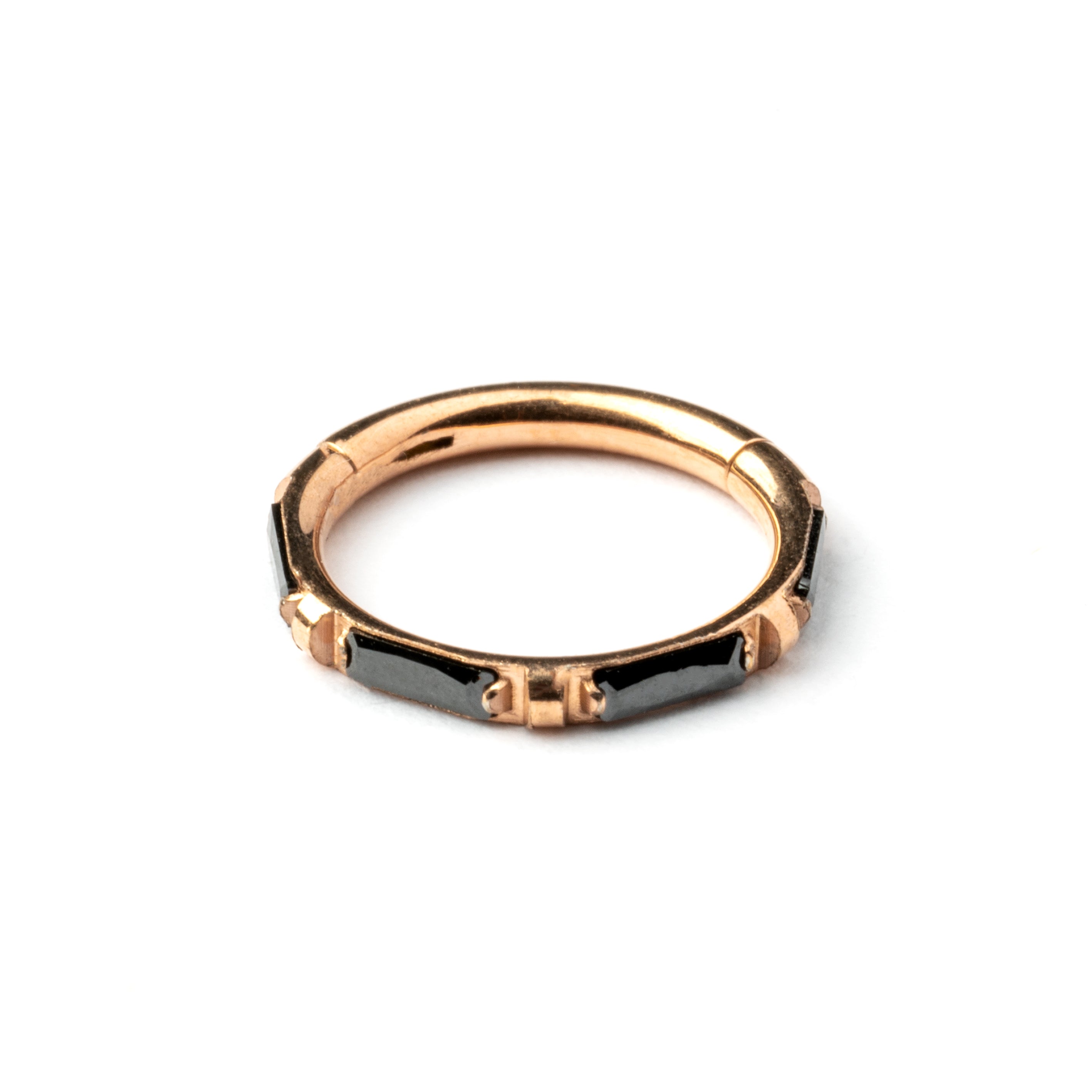 Rose Gold septum clicker with black onyx stones around its rim frontal view