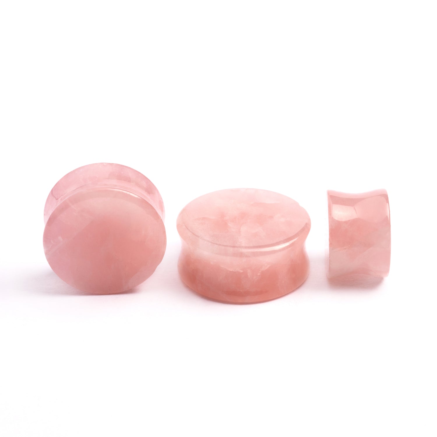 several sizes of rose quartz double flare stone ear plugs front and side view