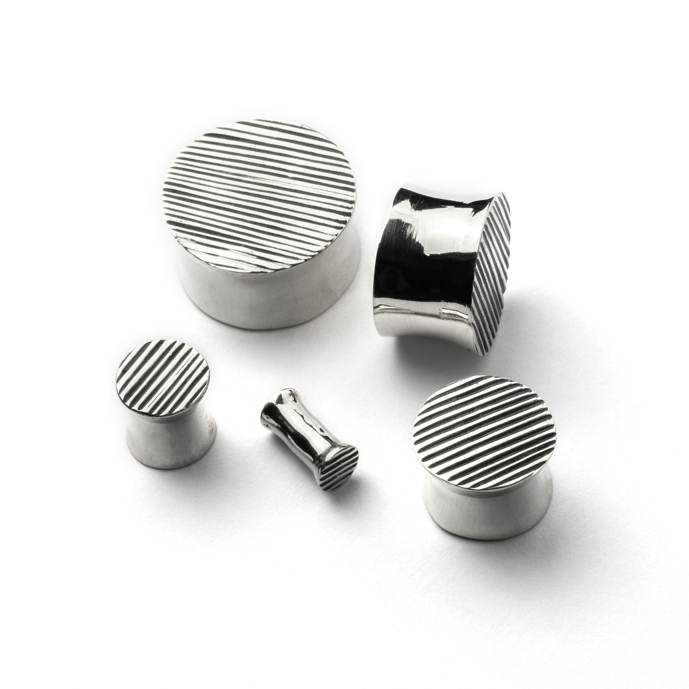 several sizes of scratched double flared ear plugs all sides view