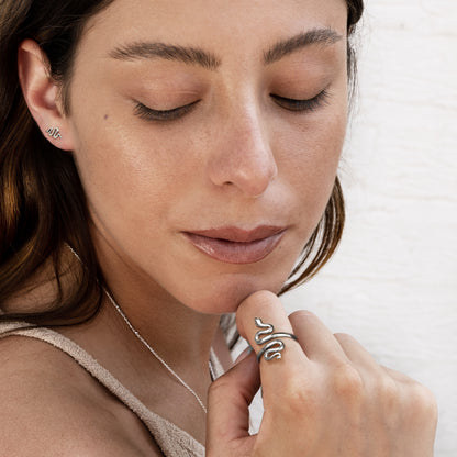 model wearing Snake silver stud earrings and a matching snake ring