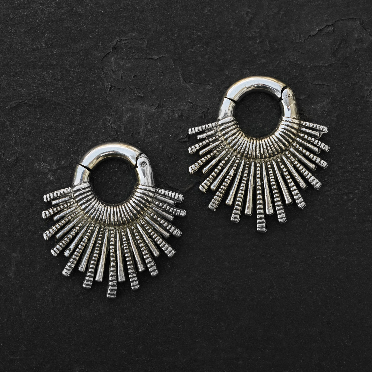 pair of silver brass tribal sun hoops hangers frontal view black background