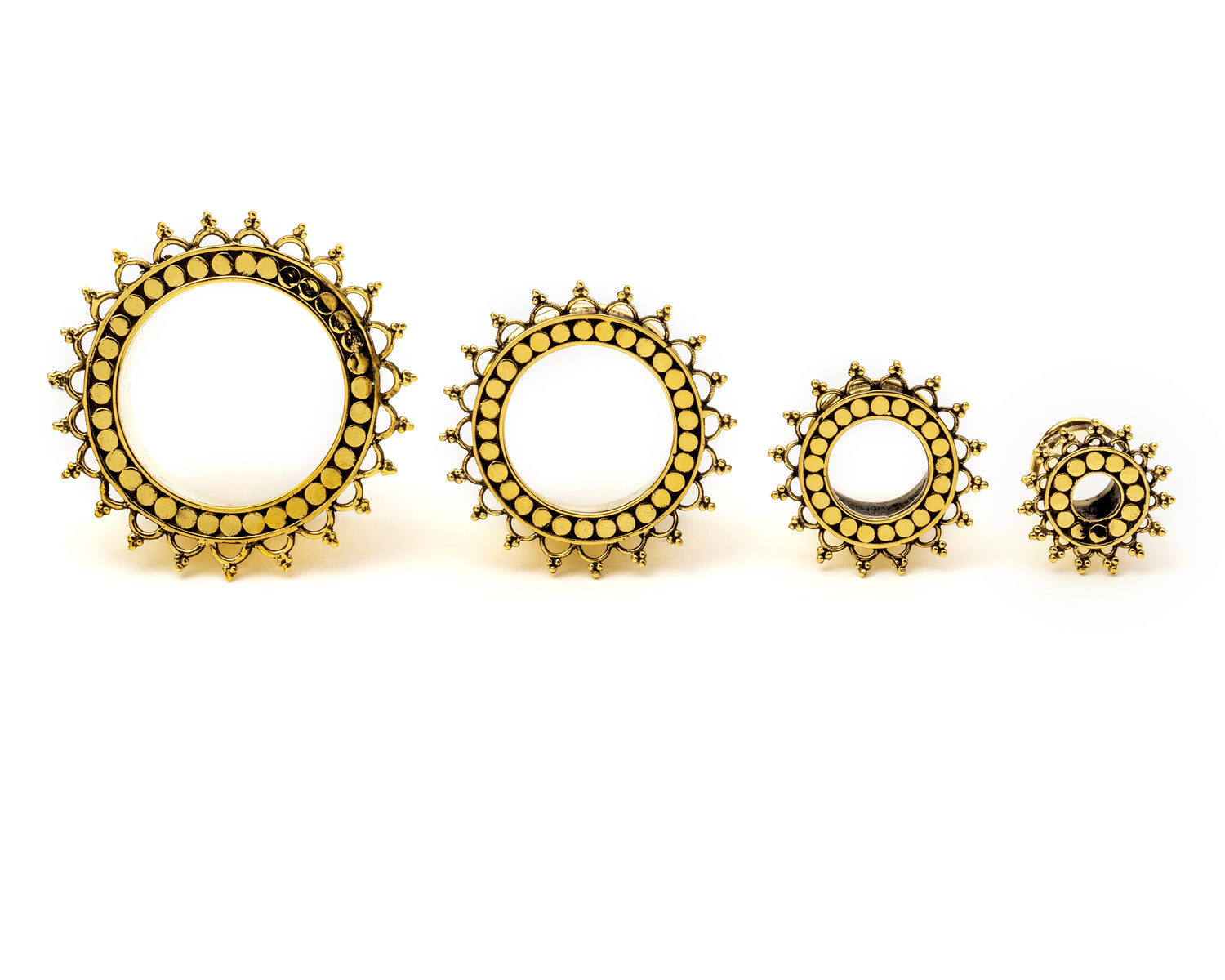 several sizes of golden brass tribal flower ear tunnels frontal view