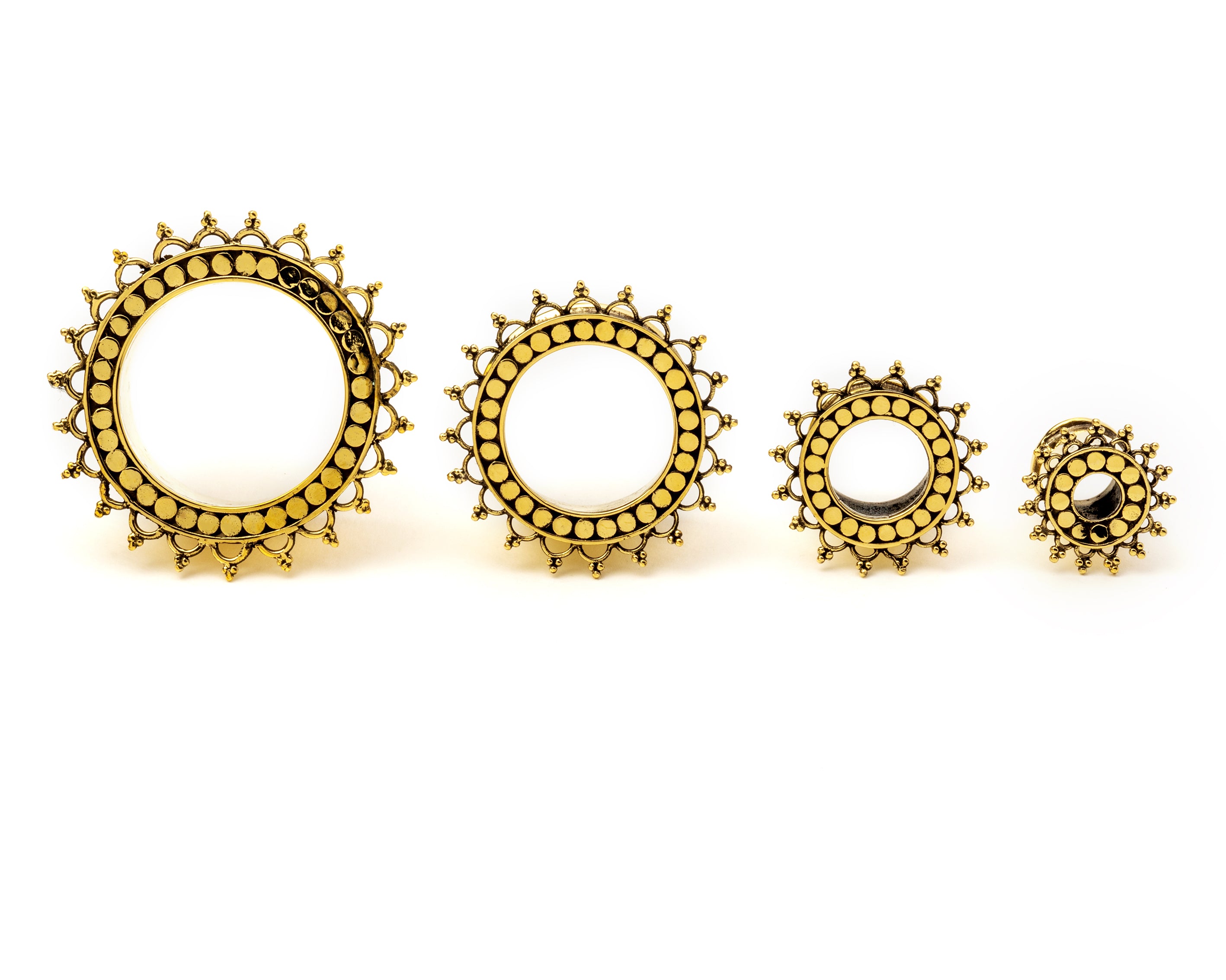 several sizes of golden brass tribal flower ear tunnels frontal view