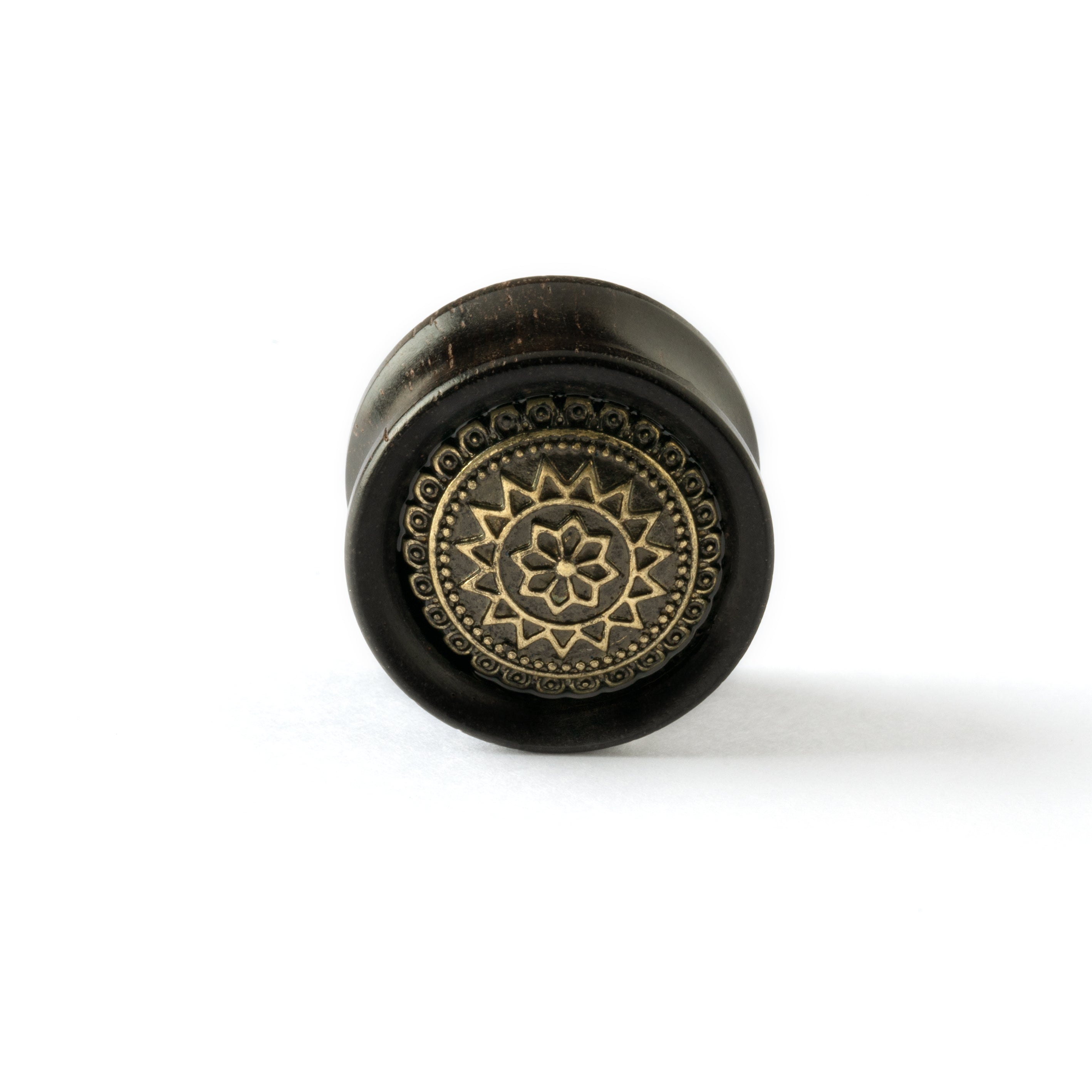 ebony wood ear plug with brass tribal flower ornament frontal view