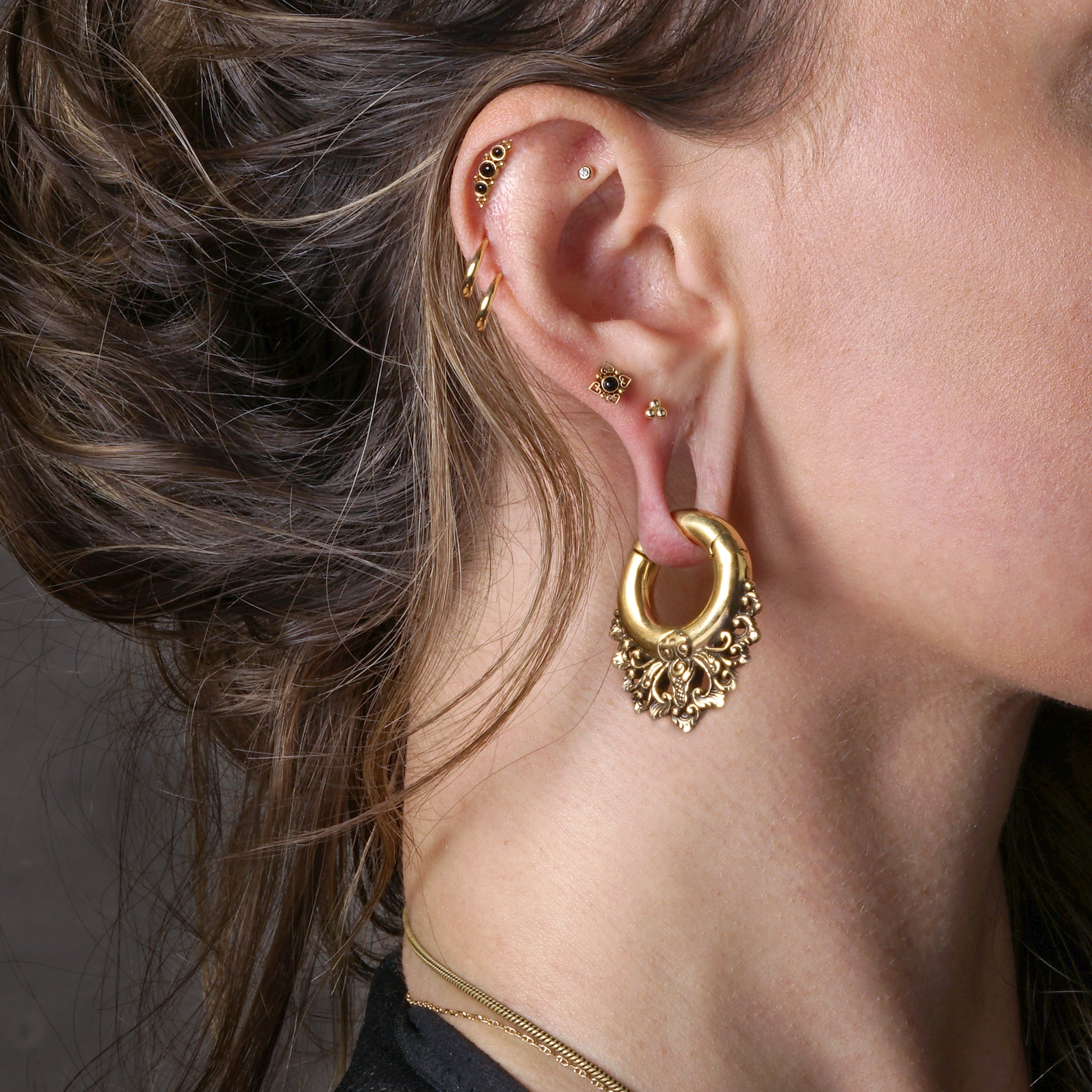 model wearing Neptune golden labret with black Onyx on her upper lobe