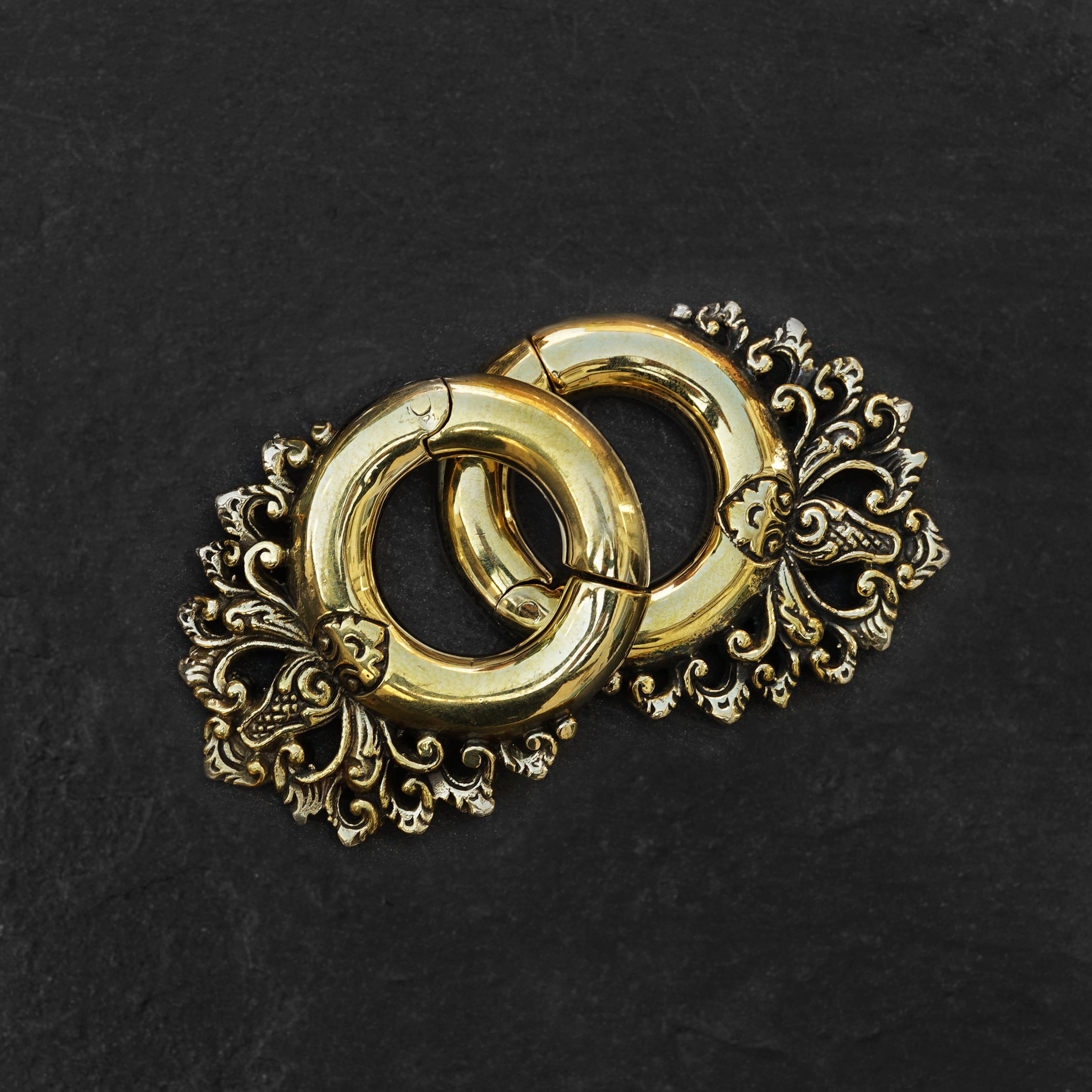 pair of gold brass ear hangers hoops with floral victorian design frontal view black background