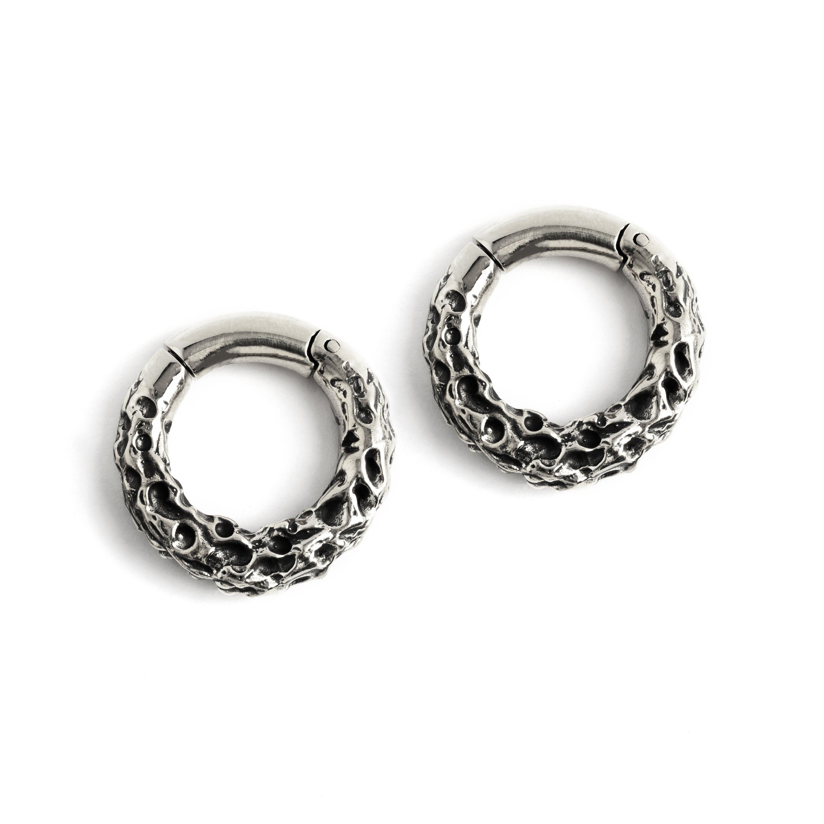Pair of silver brass hoop hangers with rocky texture frontal view