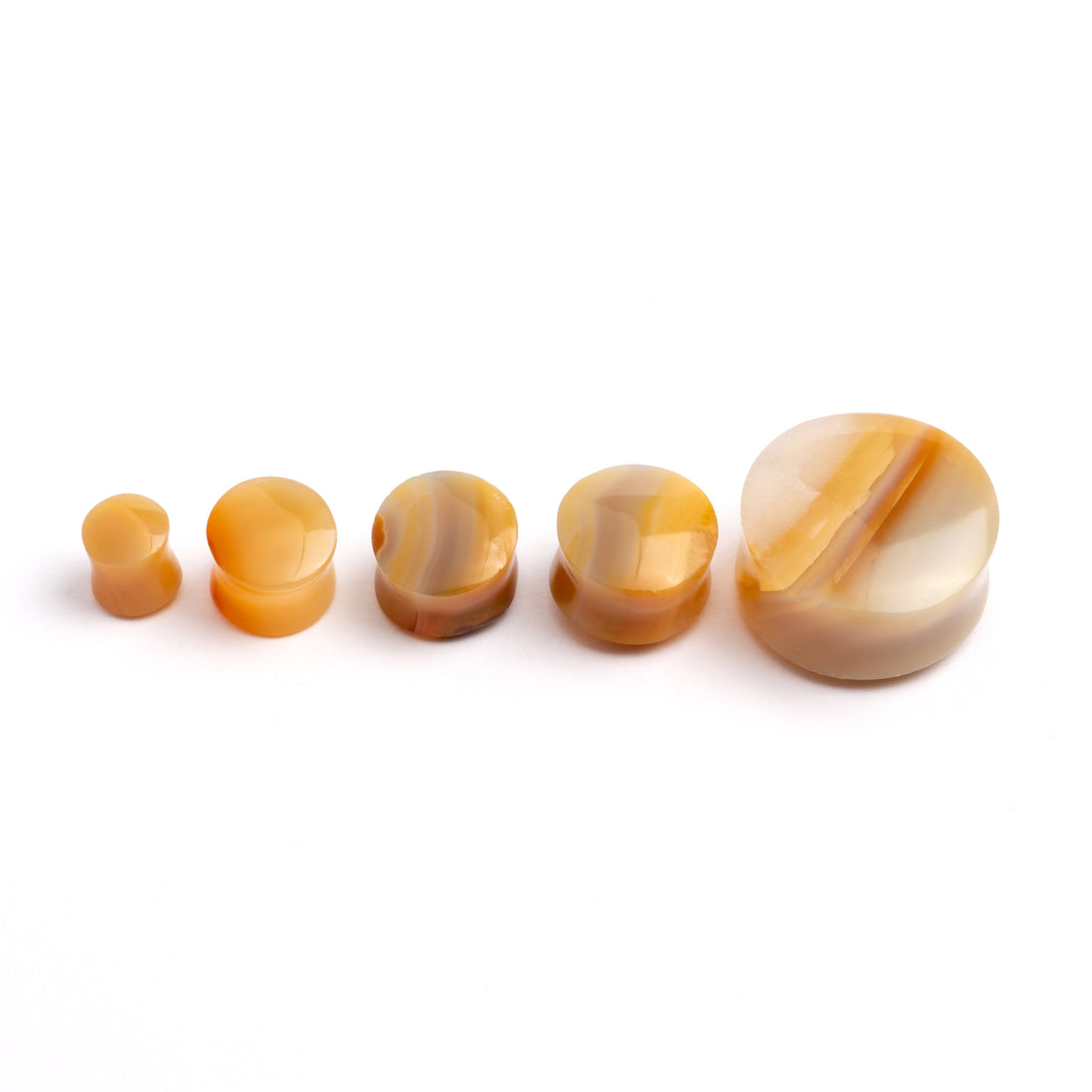 several sizes of Yellow Agate double flare stone ear plugs front view