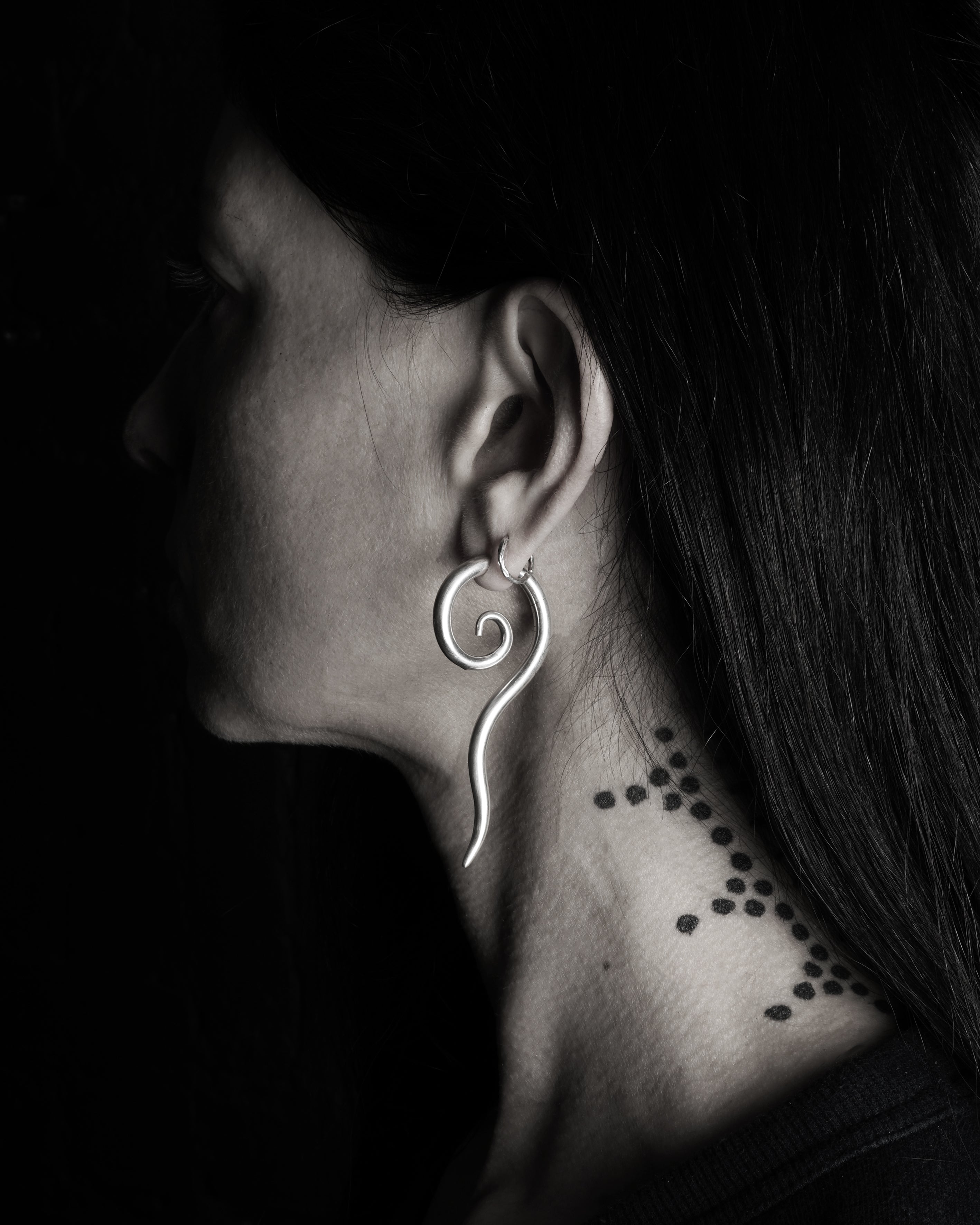 MODEL WEARING SINGLE SILVER LONG TAILED SPIRAL EAR STRETCHER HANGER