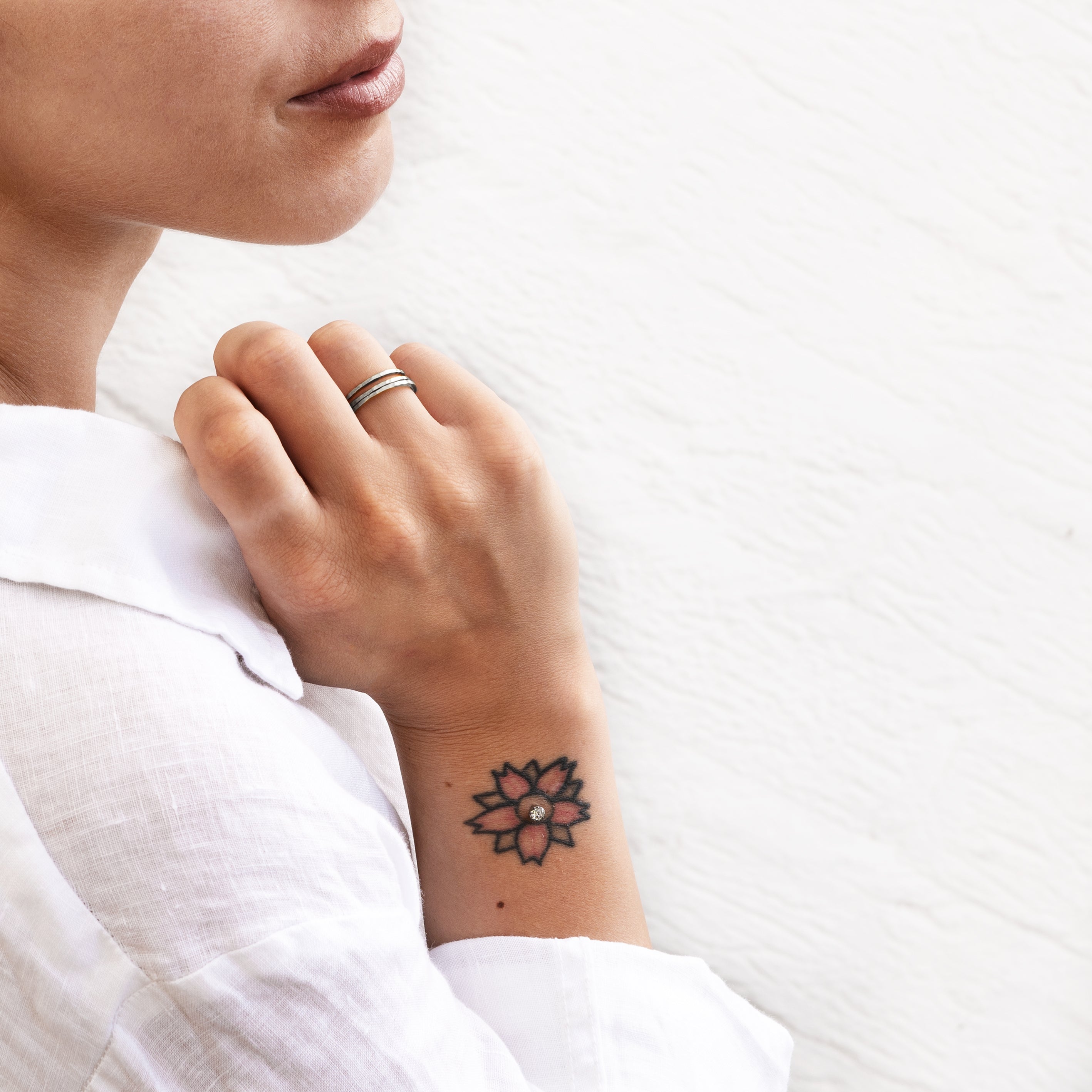 model wearing multiple hammered silver stacking band rings