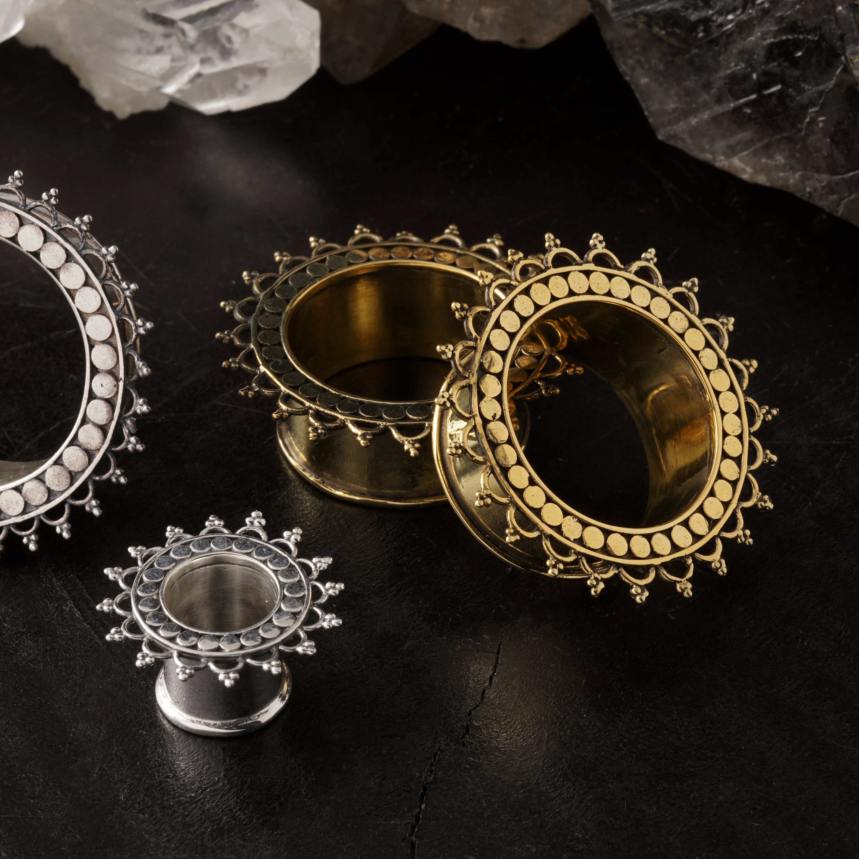 several sizes of silver and brass tribal flower tara ear tunnels