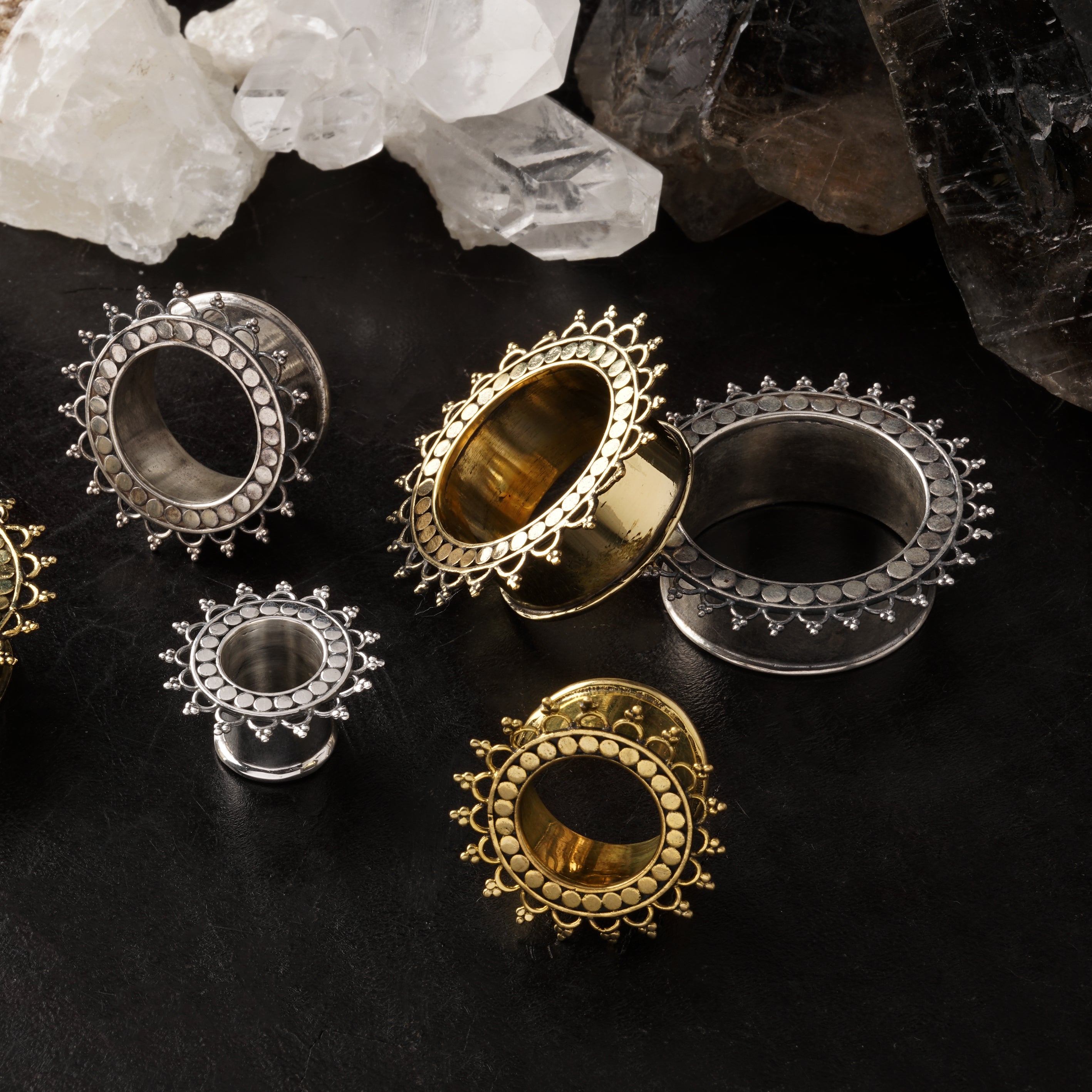 several sizes of silver and brass tribal flower tara ear tunnels