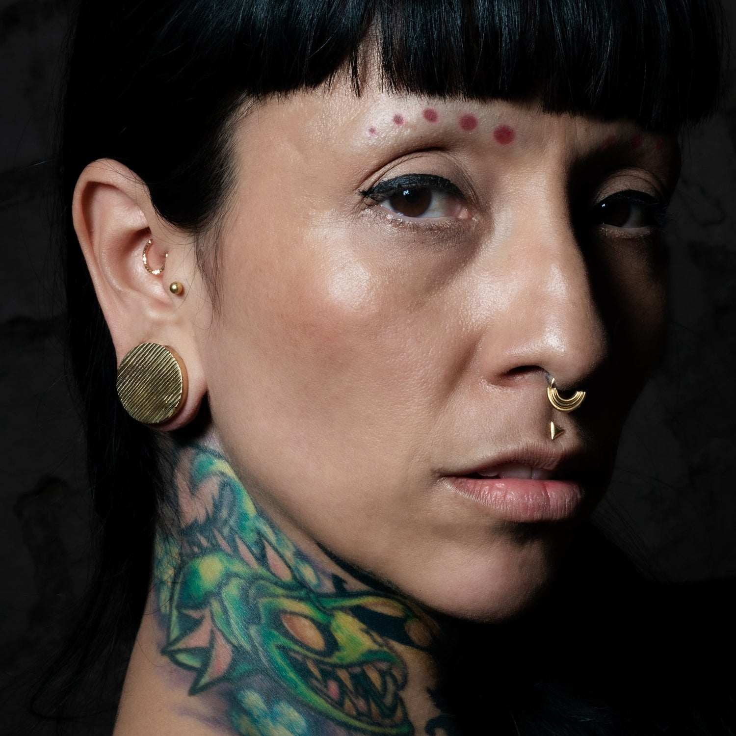 women with stretched ears wearing ear gauges, plugs tunnels