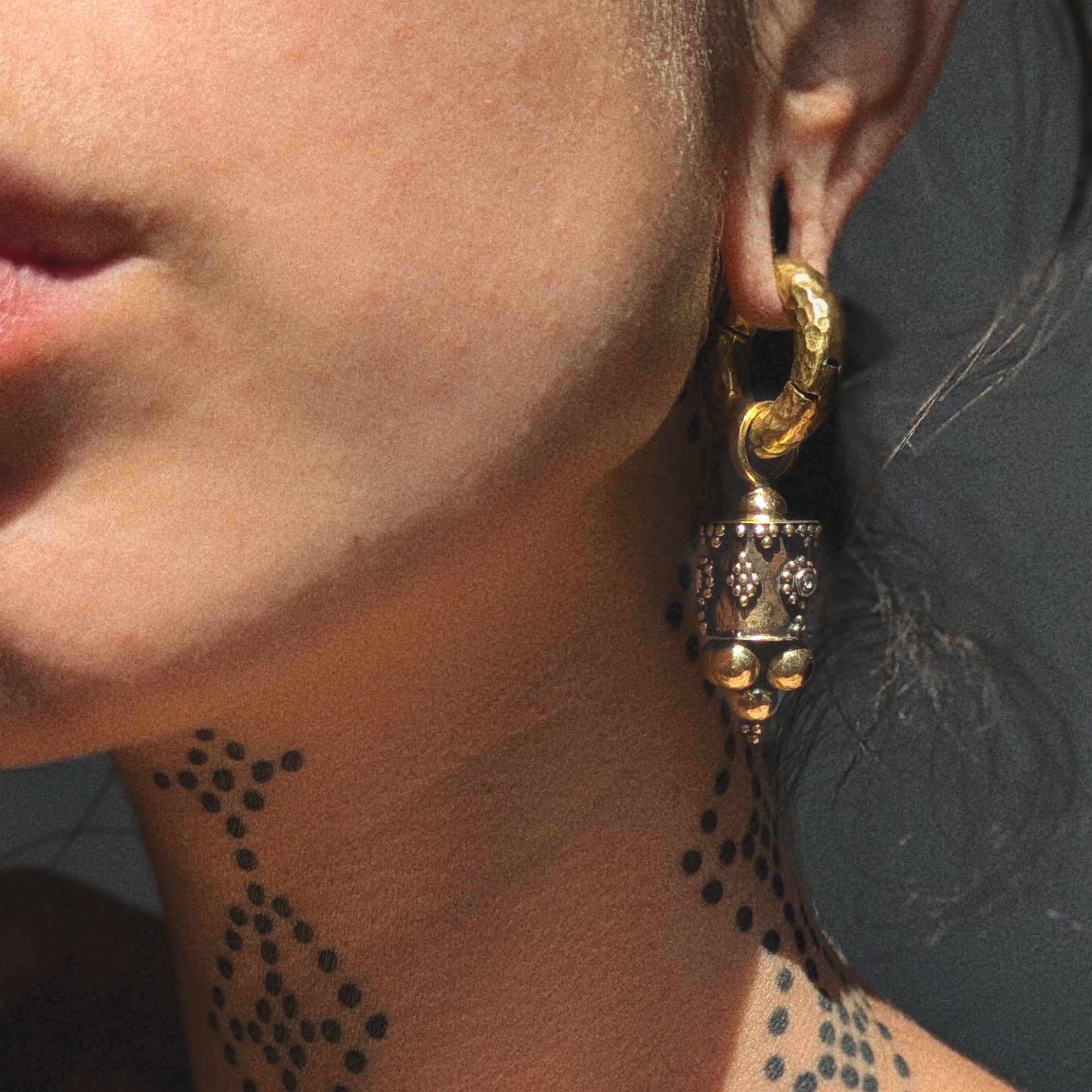 model wearing Afghan Ear Weights with Topaz