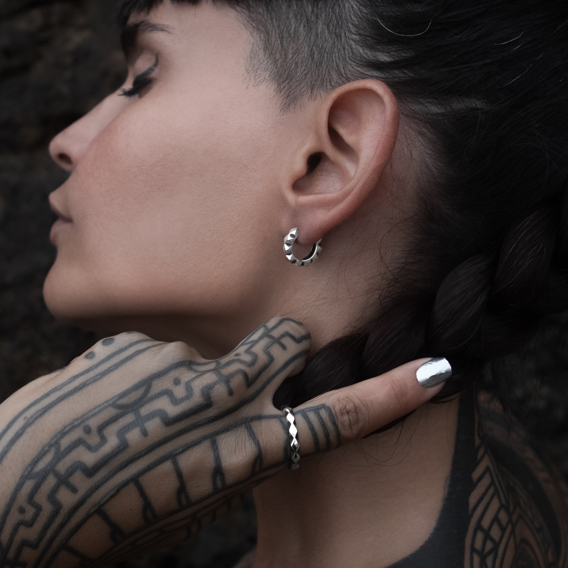 model wearing Silver Rhombus Huggie Hoops earrings and a matching Rhombus ring