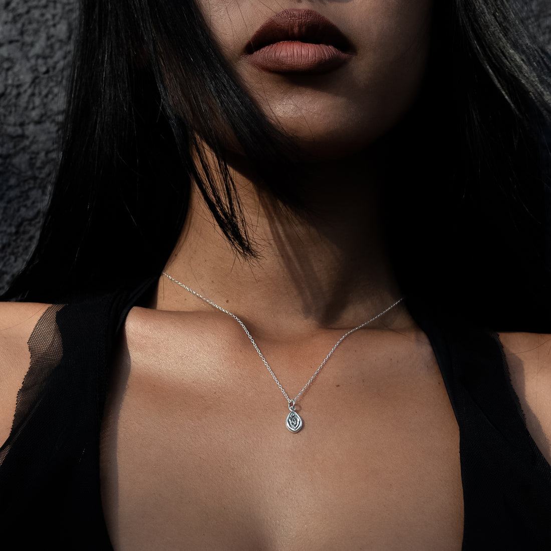 model wearing silver Yoni charm