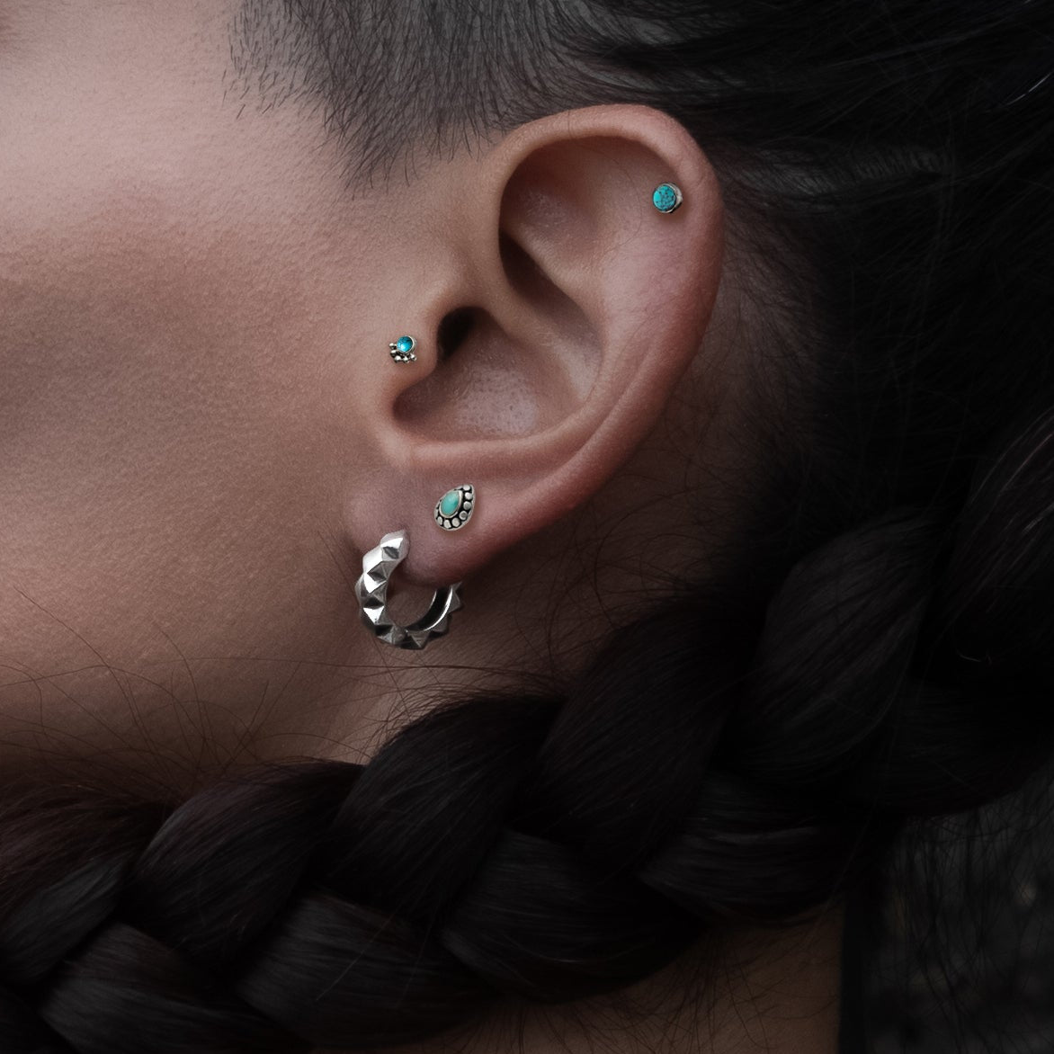 model wearing Layla Labret with Turquoise on her tragus, Tarat labret on her upper lobe and titanium labret on her helix