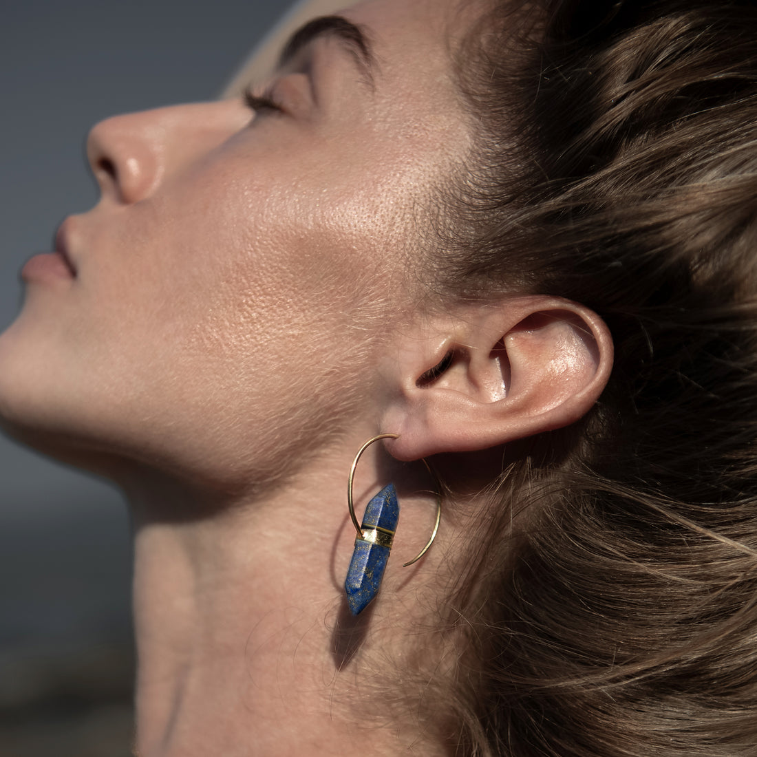 model wearing golden Zen open Hoop Earrings with Lapis lazuli