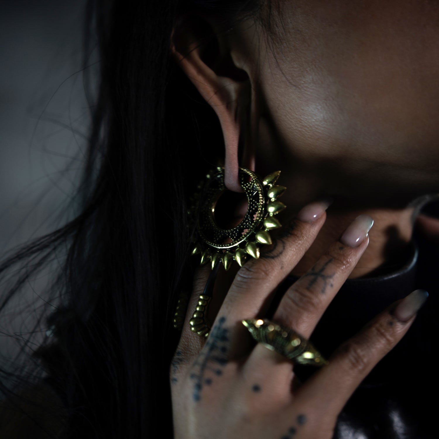 pair of gold brass tribal spiky ear weights hoops on a model