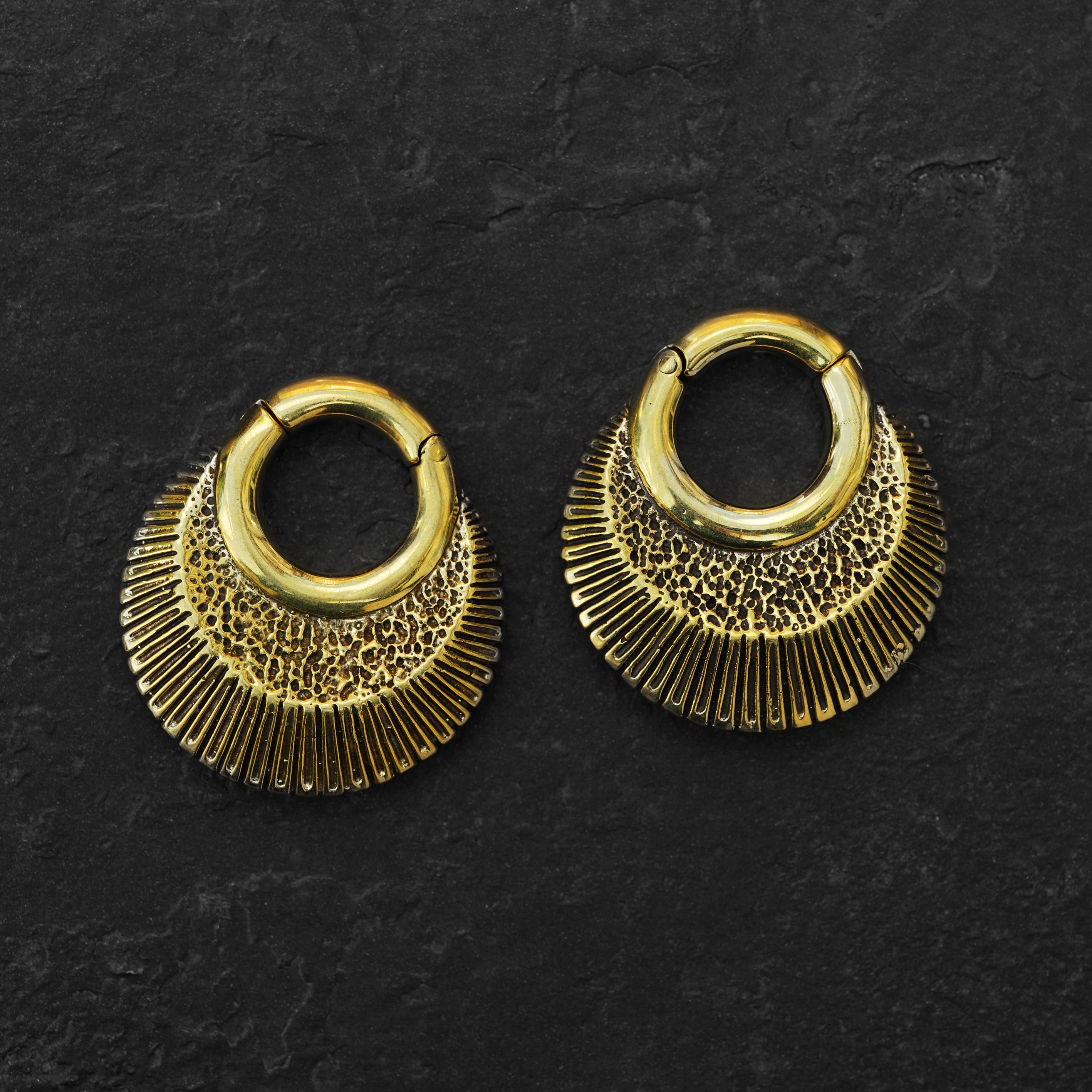 Brass African clicker Hoop Gauge Earrings ear weights hangers front black background