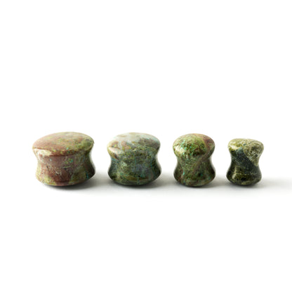 several sizes of African Green Jade double flare stone ear plugs side view