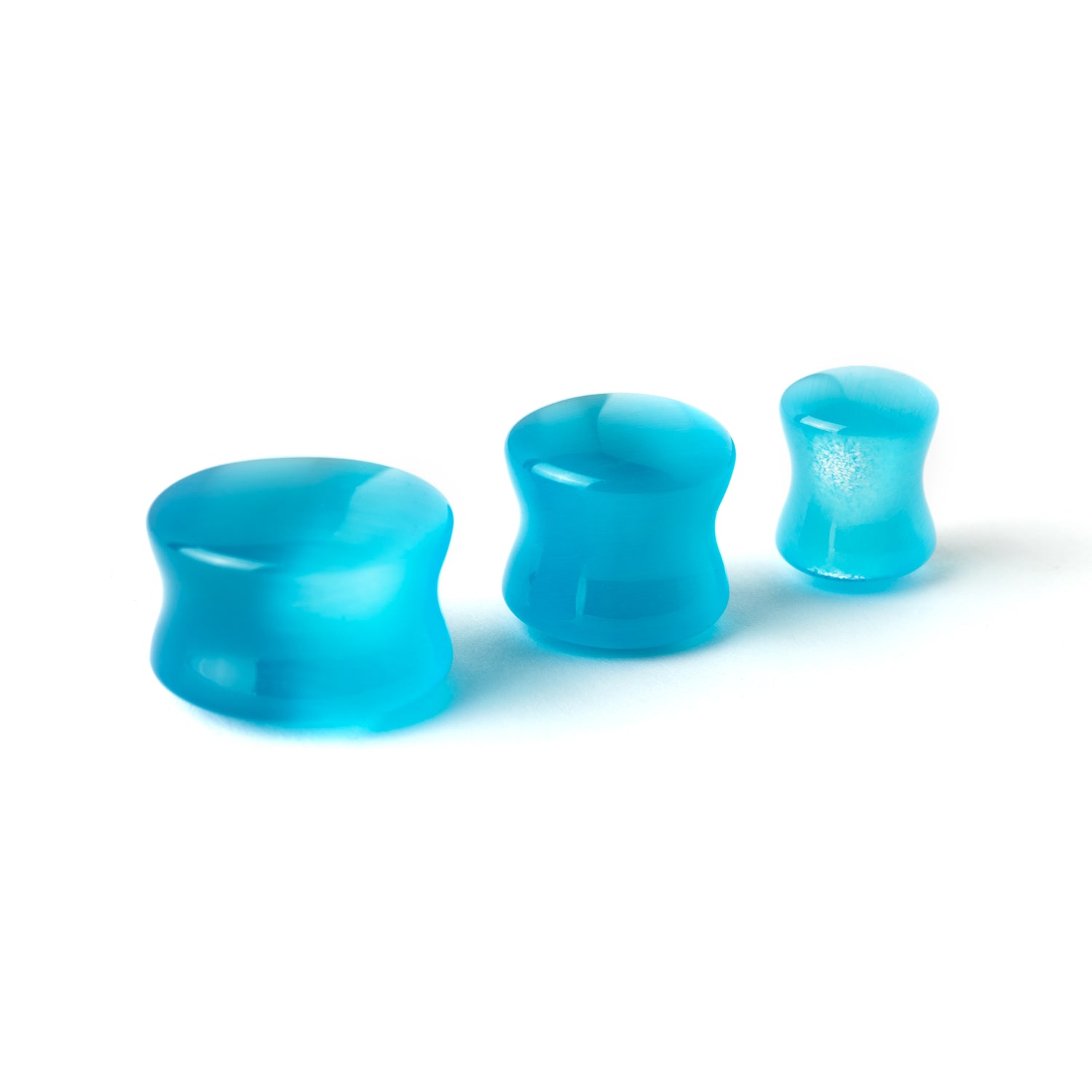 several sizes of Aqua Cats Eye double flare stone ear plugs side view